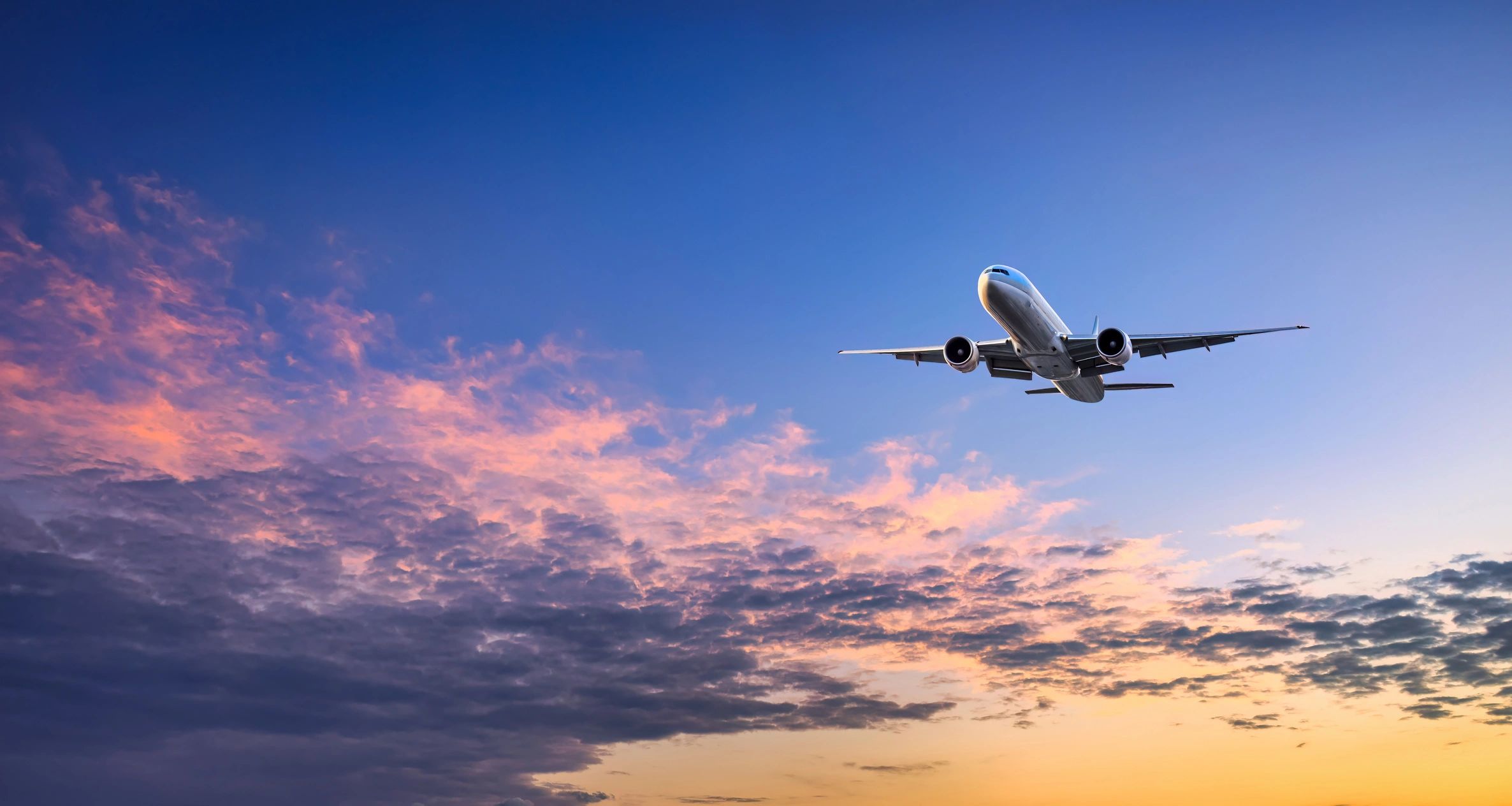 An airliner climbing away at sunset, an example of plane spotting photography at a major airport, by Piemags Aviation.