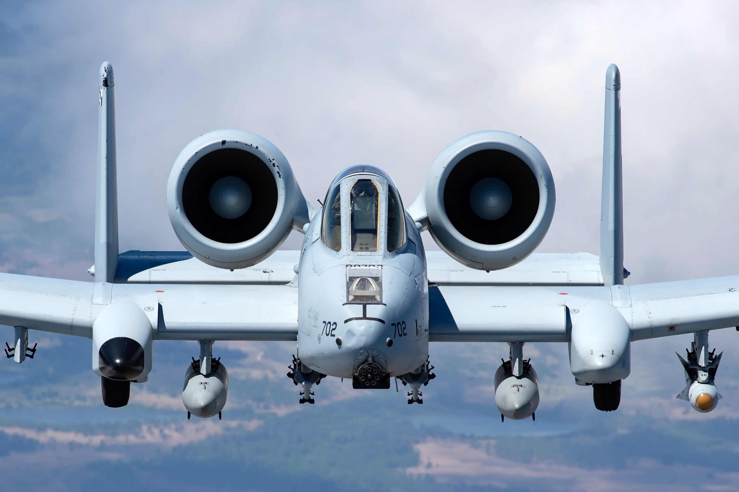 Tight head-on close-up of A-10C 78-0702 showing the GAU-8 cannon muzzle between the engine nacelles