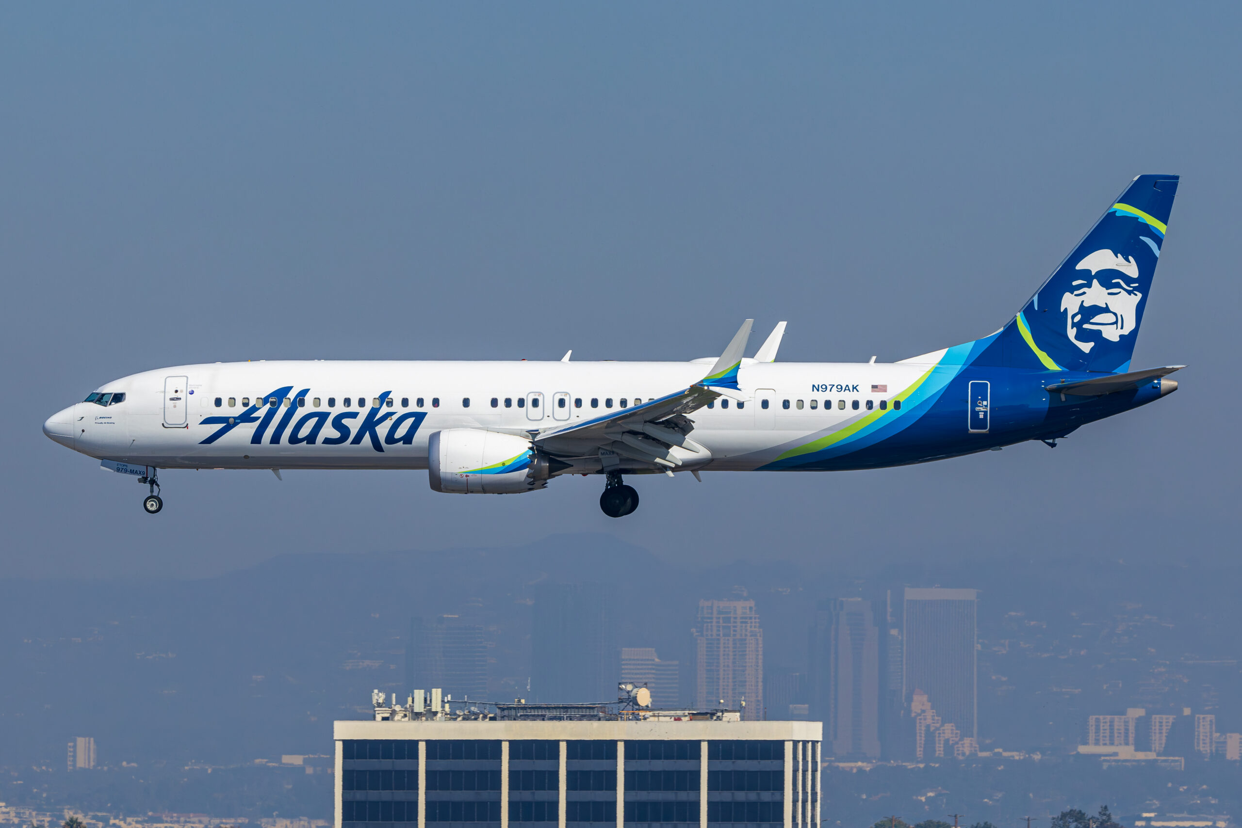 Alaska Airlines Boeing 737-9 MAX N979AK on approach with a hazy city skyline behind