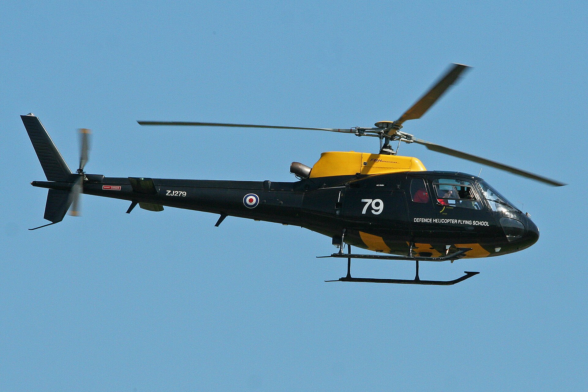 Defence Helicopter Flying School Squirrel HT1 ZJ279 in flight against a clear blue sky with blurred rotor blades