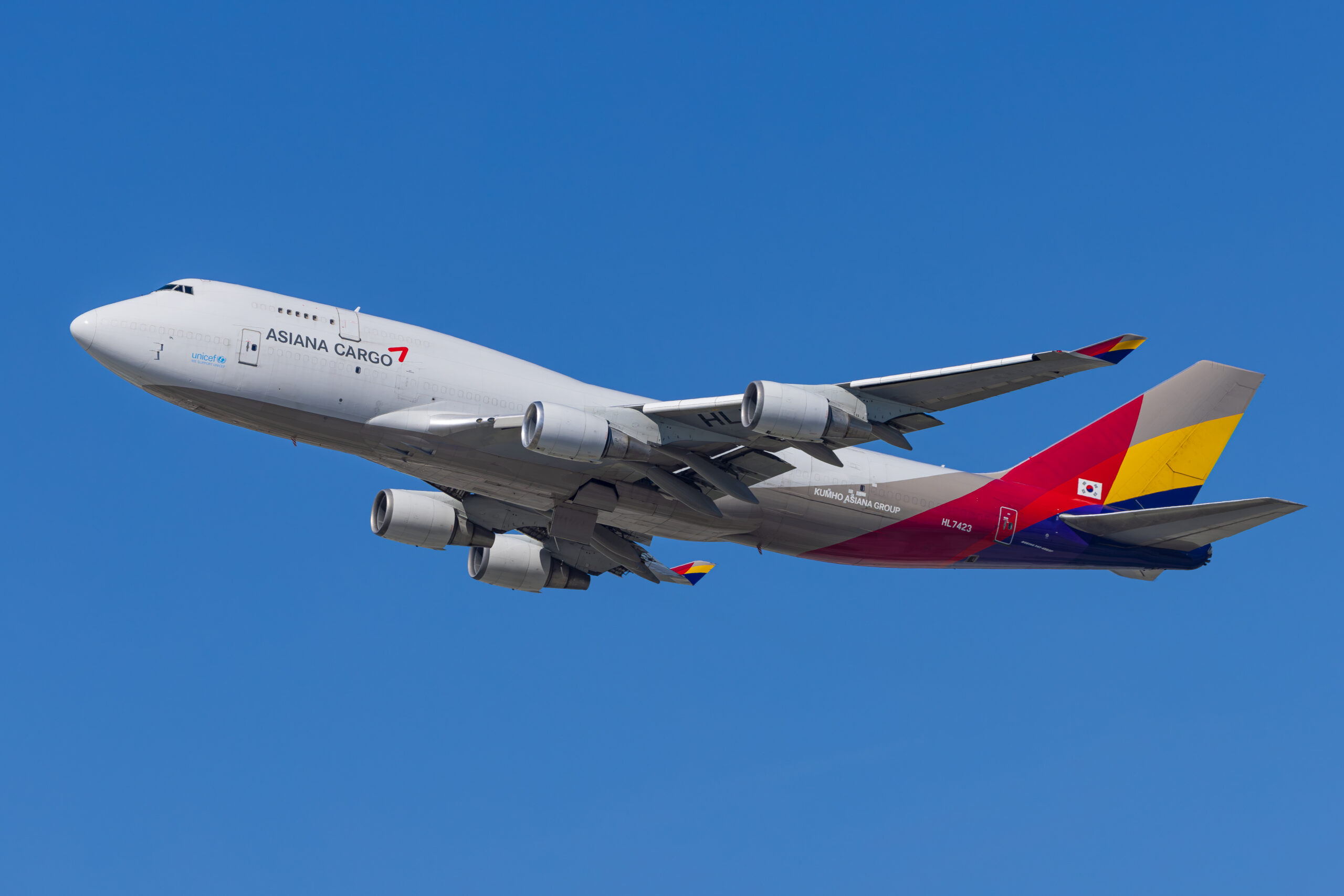 Asiana Cargo Boeing 747-400F HL7423 climbing steeply after takeoff against clear blue sky, gear still extended
