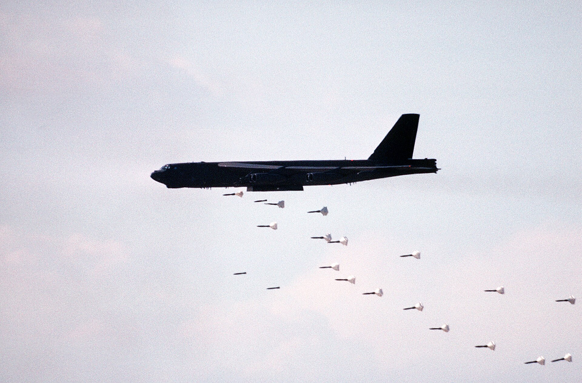 A B-52H Stratofortress dropping a stick of Mark 82 500-pound bombs on a target range