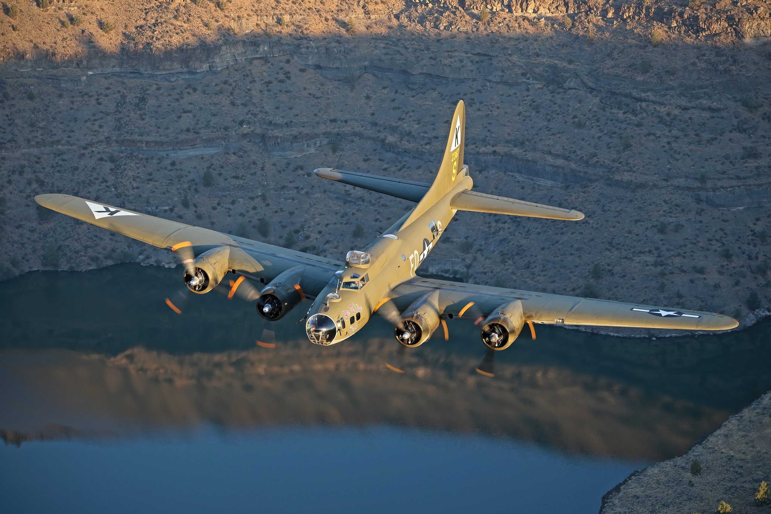 B-17 Flying Fortress Ye Olde Pub banking over a lake, air to air