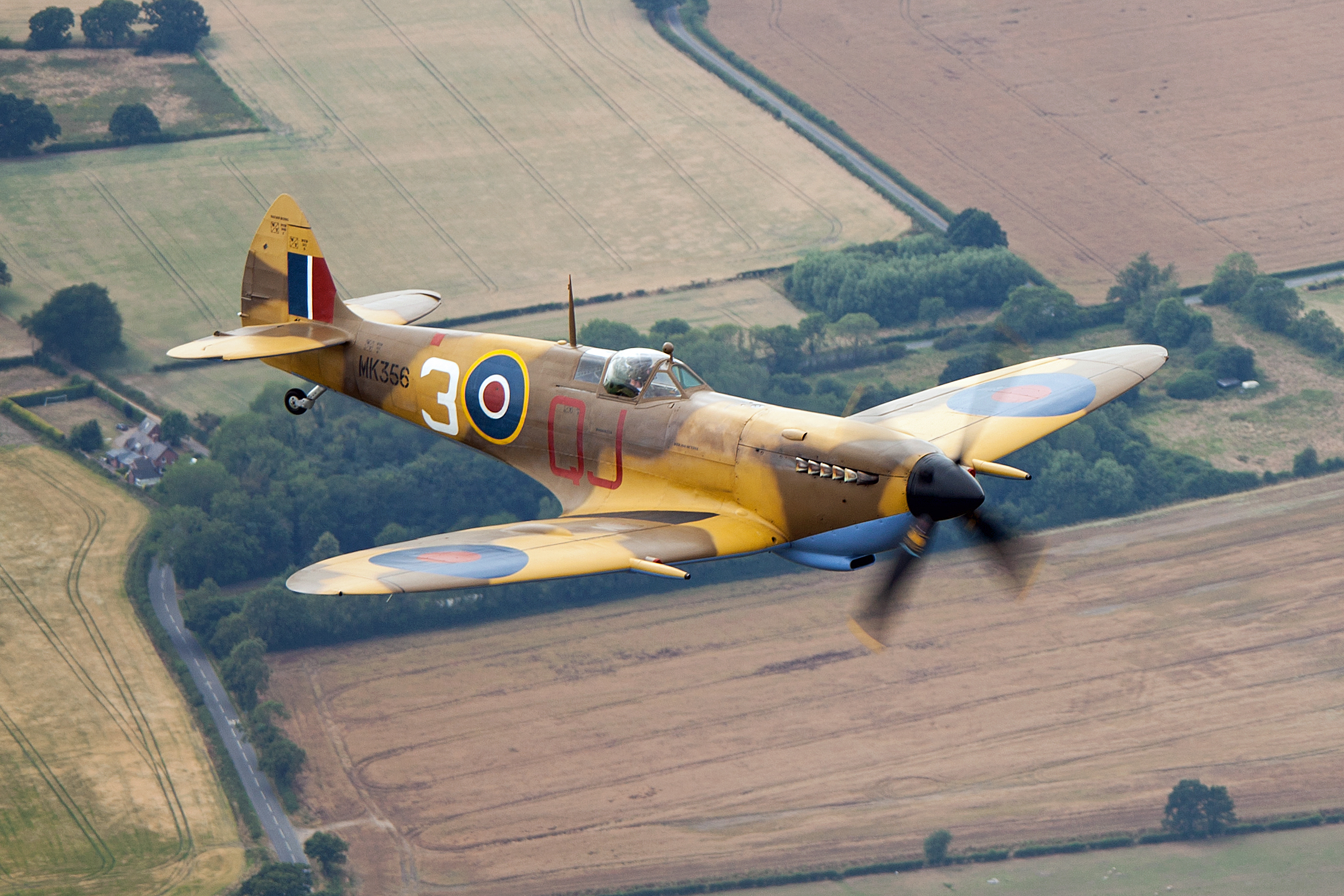 Battle of Britain Memorial Flight Supermarine Spitfire LF.9E MK356 in desert camouflage flying over English fields