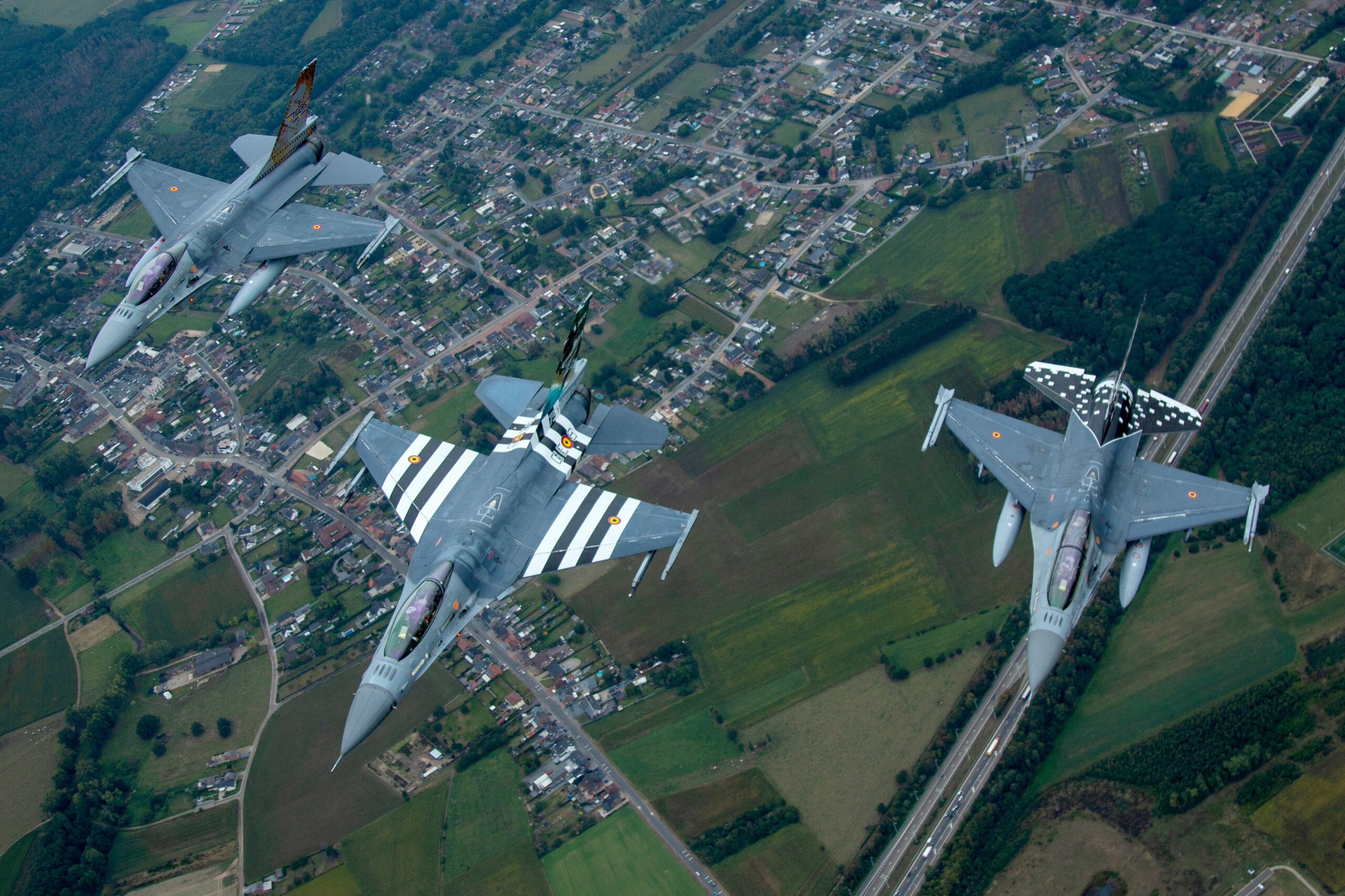 Three Belgian Air Force F-16 Fighting Falcons, including a D-Day striped special scheme, flying in formation