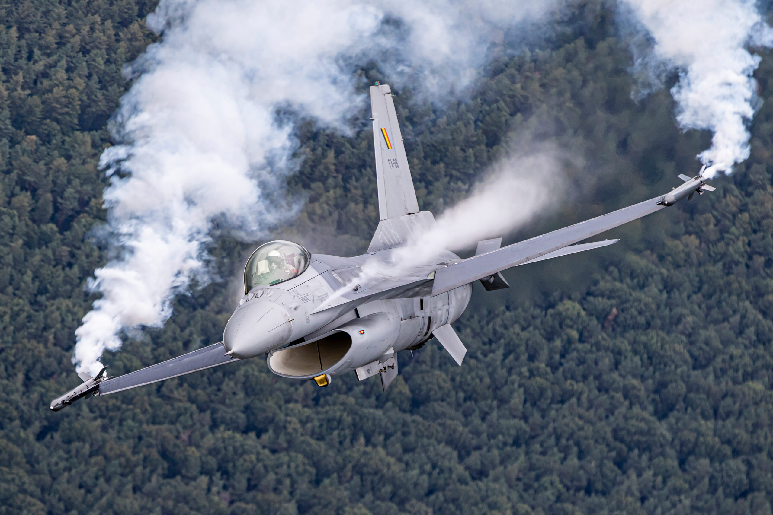 Belgian Air Force F-16 banking with condensation over the wing