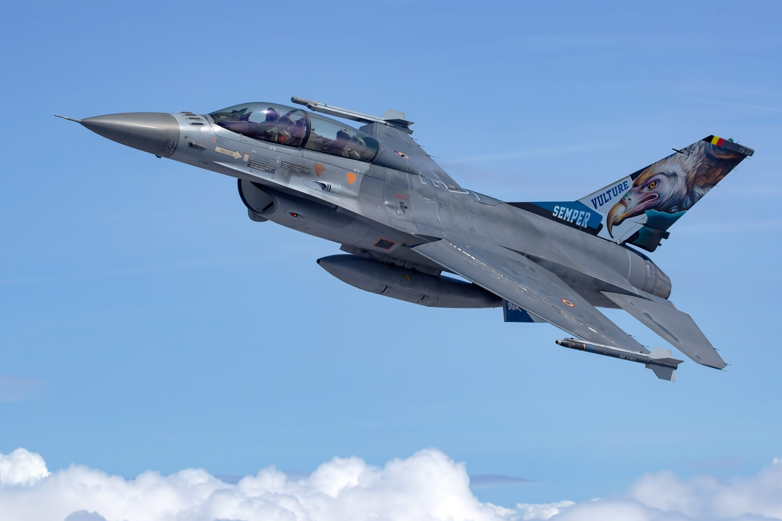 Belgian Air Force two-seat F-16BM FB-24 climbing above clouds with Semper Vulture eagle artwork on the tail