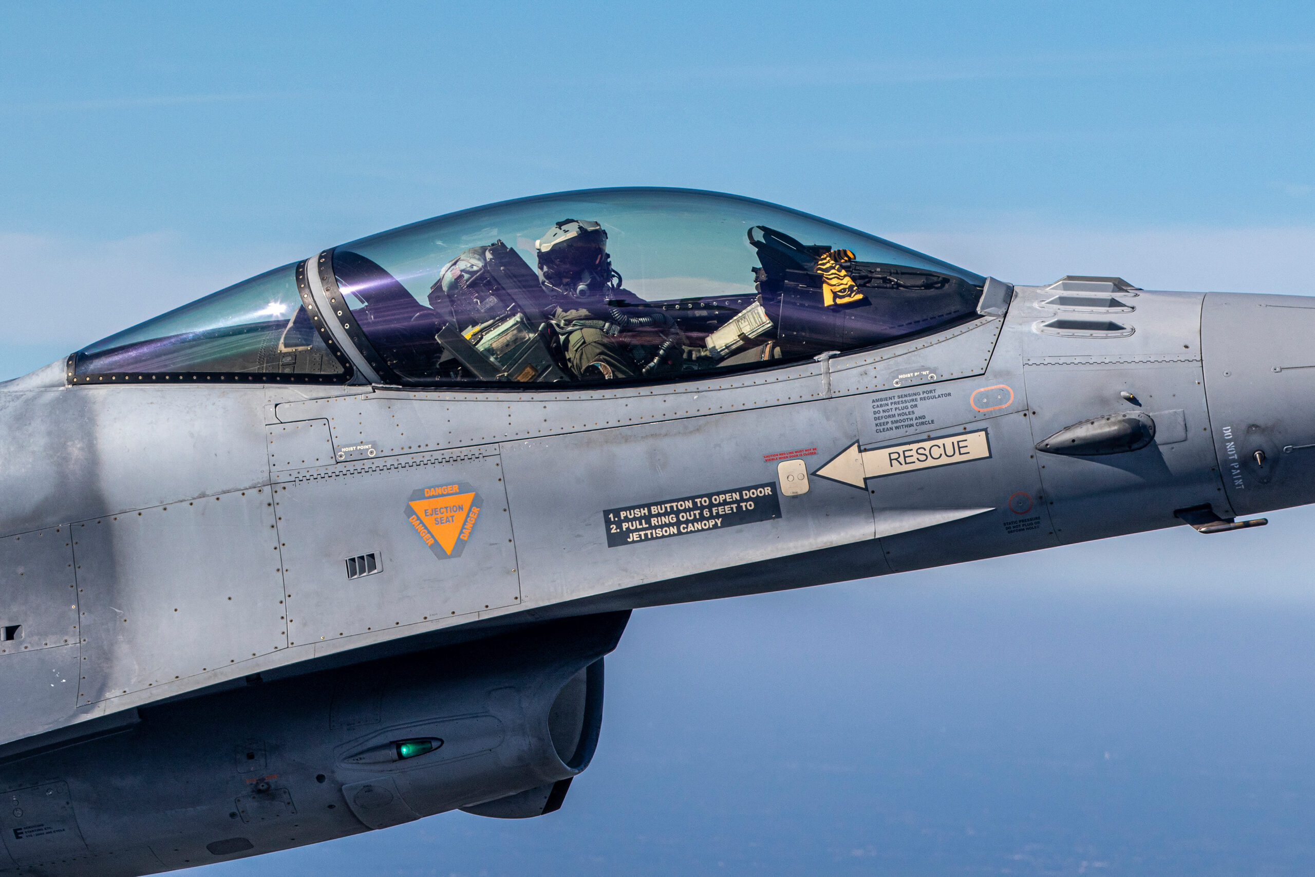 Extreme close-up of a Belgian F-16 canopy with pilot and tiger marking