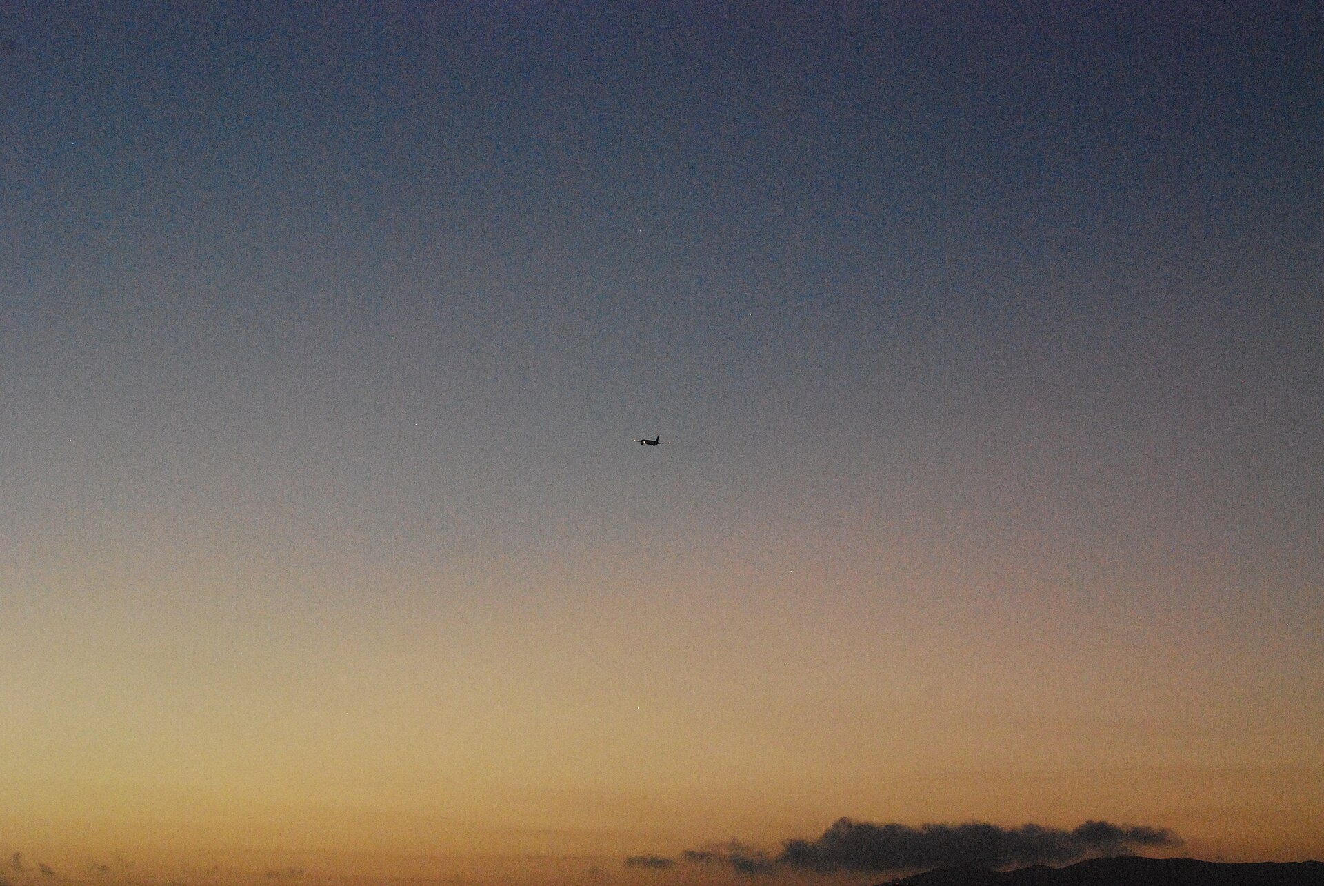 Boeing 757 climbing against a colourful sky after sunset