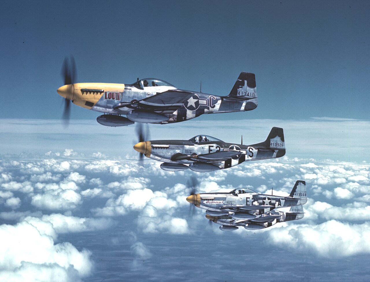 Four P-51 Mustang fighters in flight