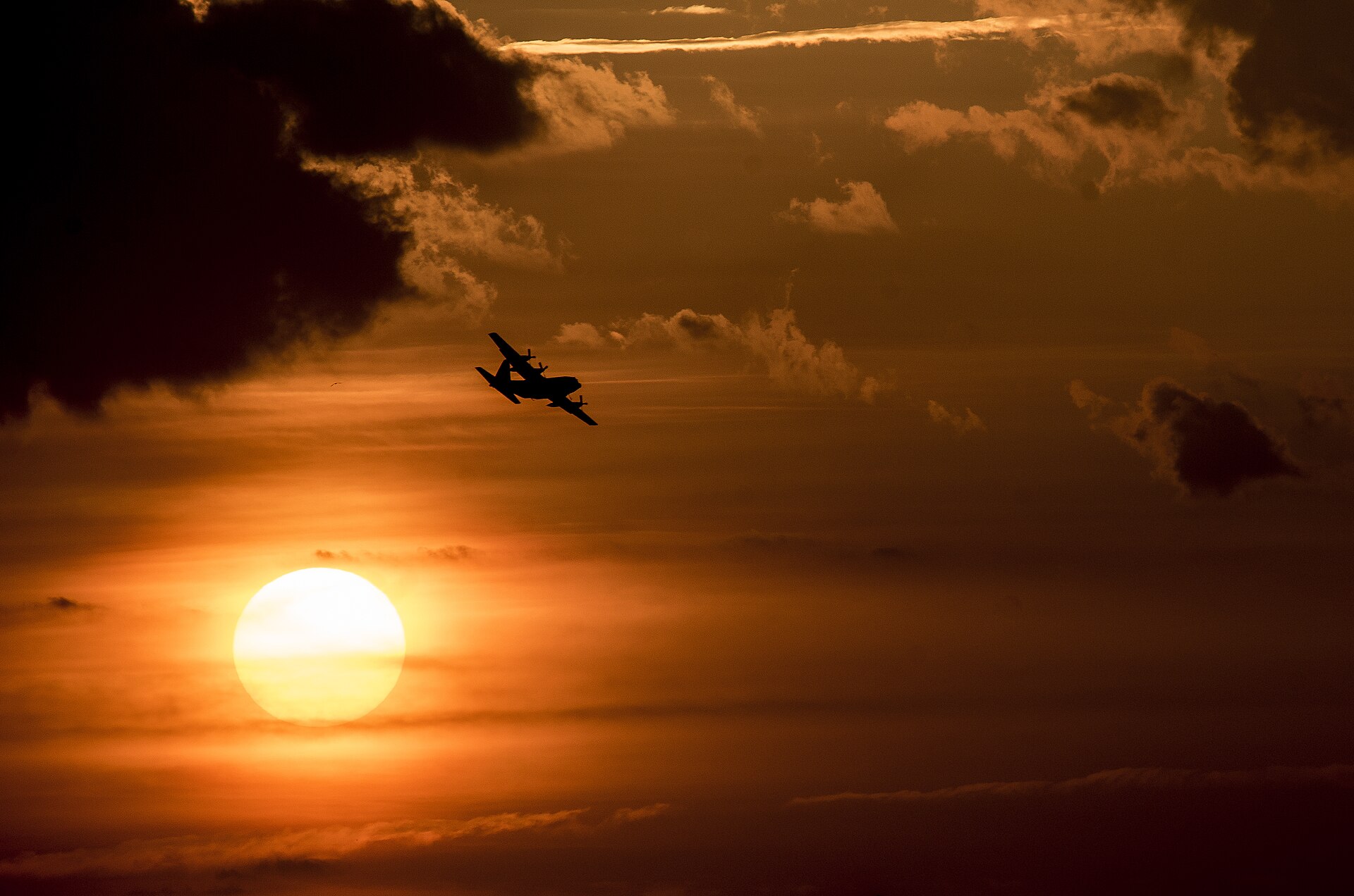 A C-130 Hercules silhouetted at sunset