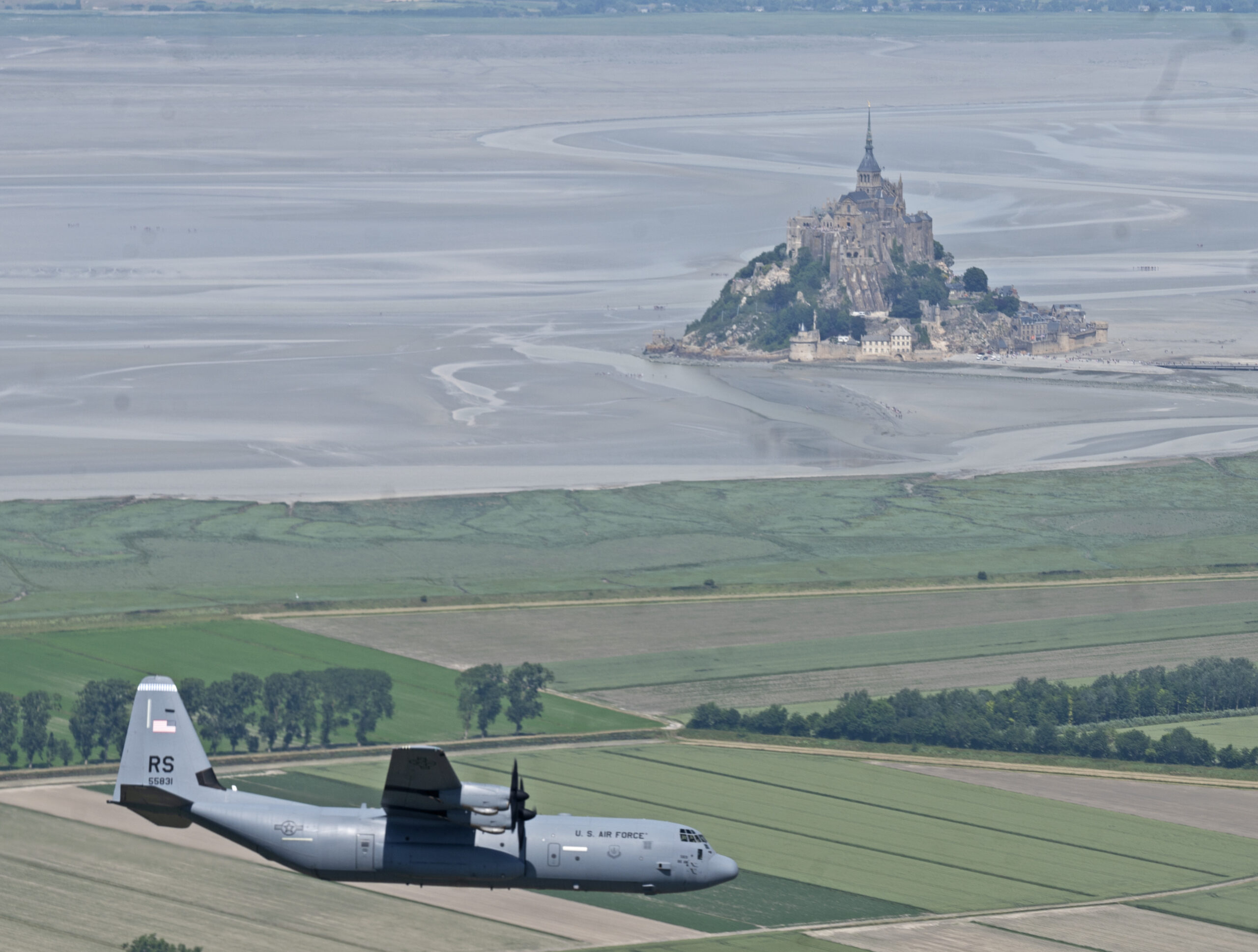 A USAF C-130J-30 Super Hercules with six bladed propellers flying past Mont Saint-Michel in 2022