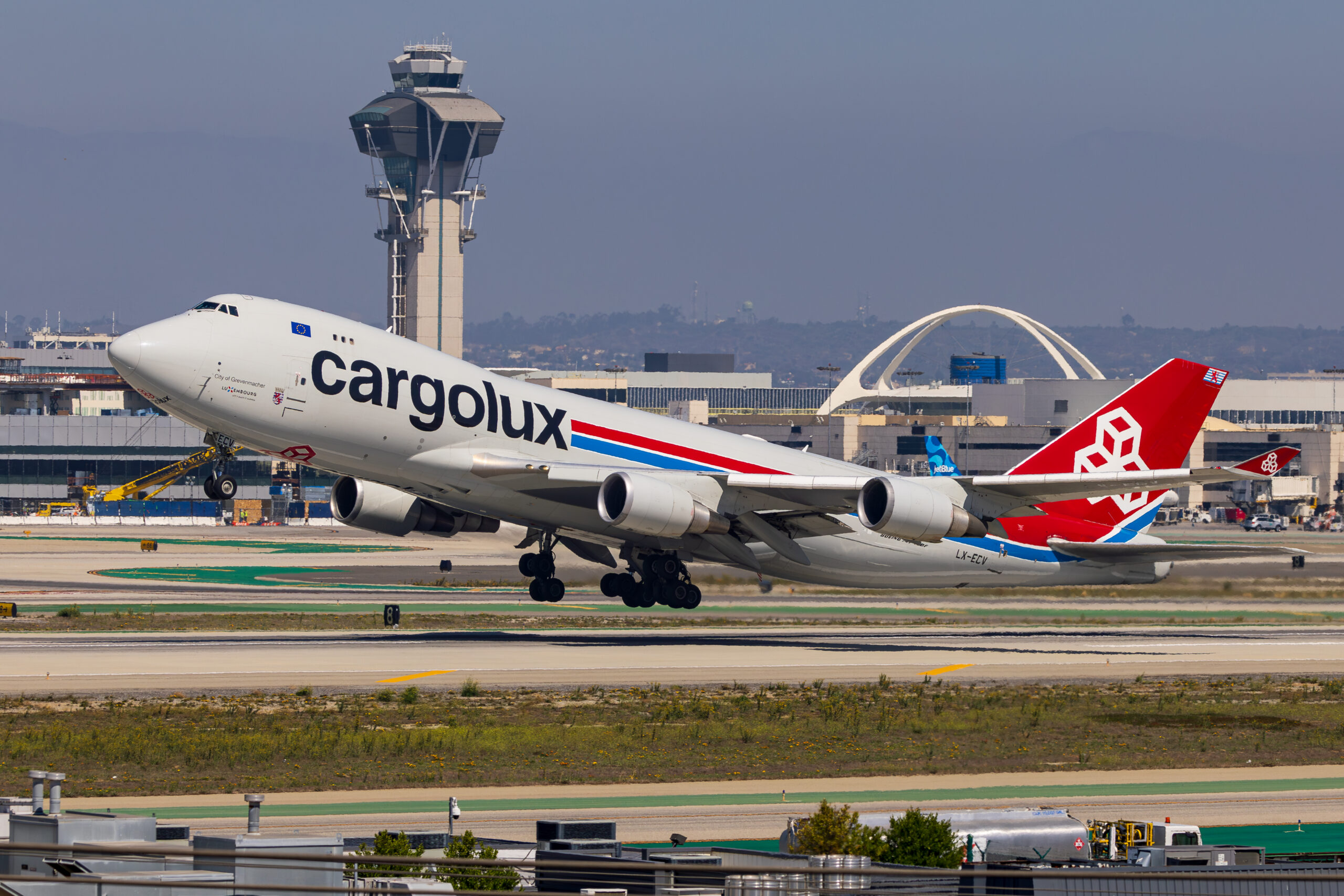 Cargolux Boeing 747-400F LX-ECV City of Grevenmacher rotating off the runway at Los Angeles International with the LAX control tower and Theme Building behind