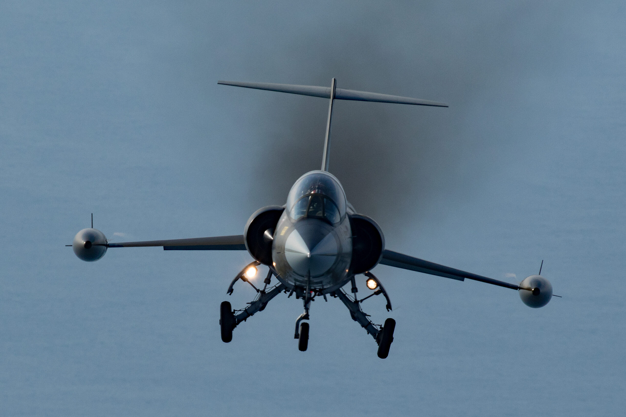 CF-104D Starfighter head-on with gear down, landing lights on and smoky exhaust