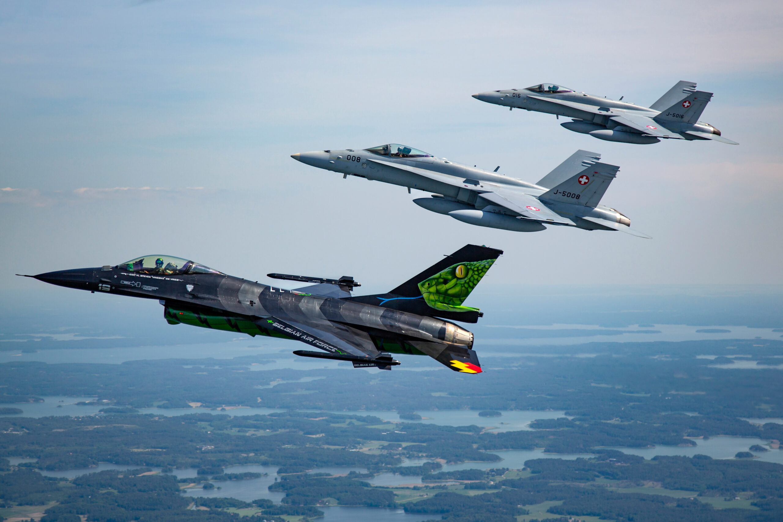 Belgian Dream Viper F-16 in formation with two Swiss F/A-18C Hornets over Finnish lakes
