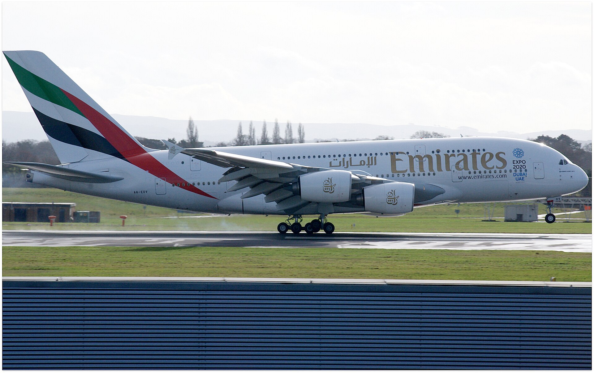 Emirates Airbus A380 on final approach to Manchester Airport, filling the frame against a grey sky
