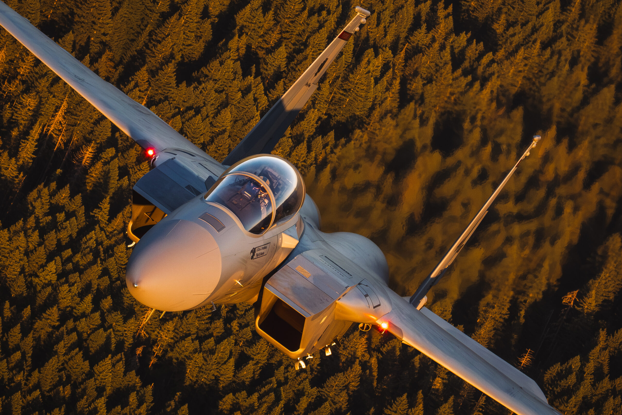 Close-up topside view of an F-15EX Eagle II cockpit and canopy in golden evening light