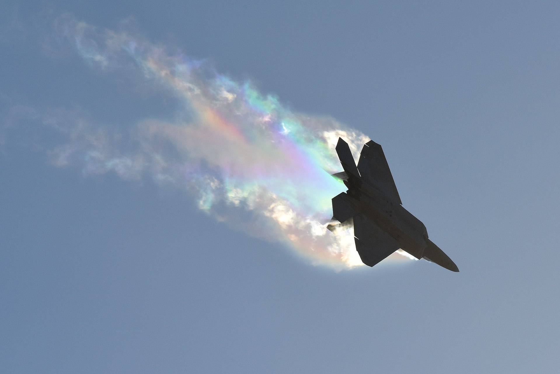USAF F-22 Raptor banking left with vapour streaming over its wings