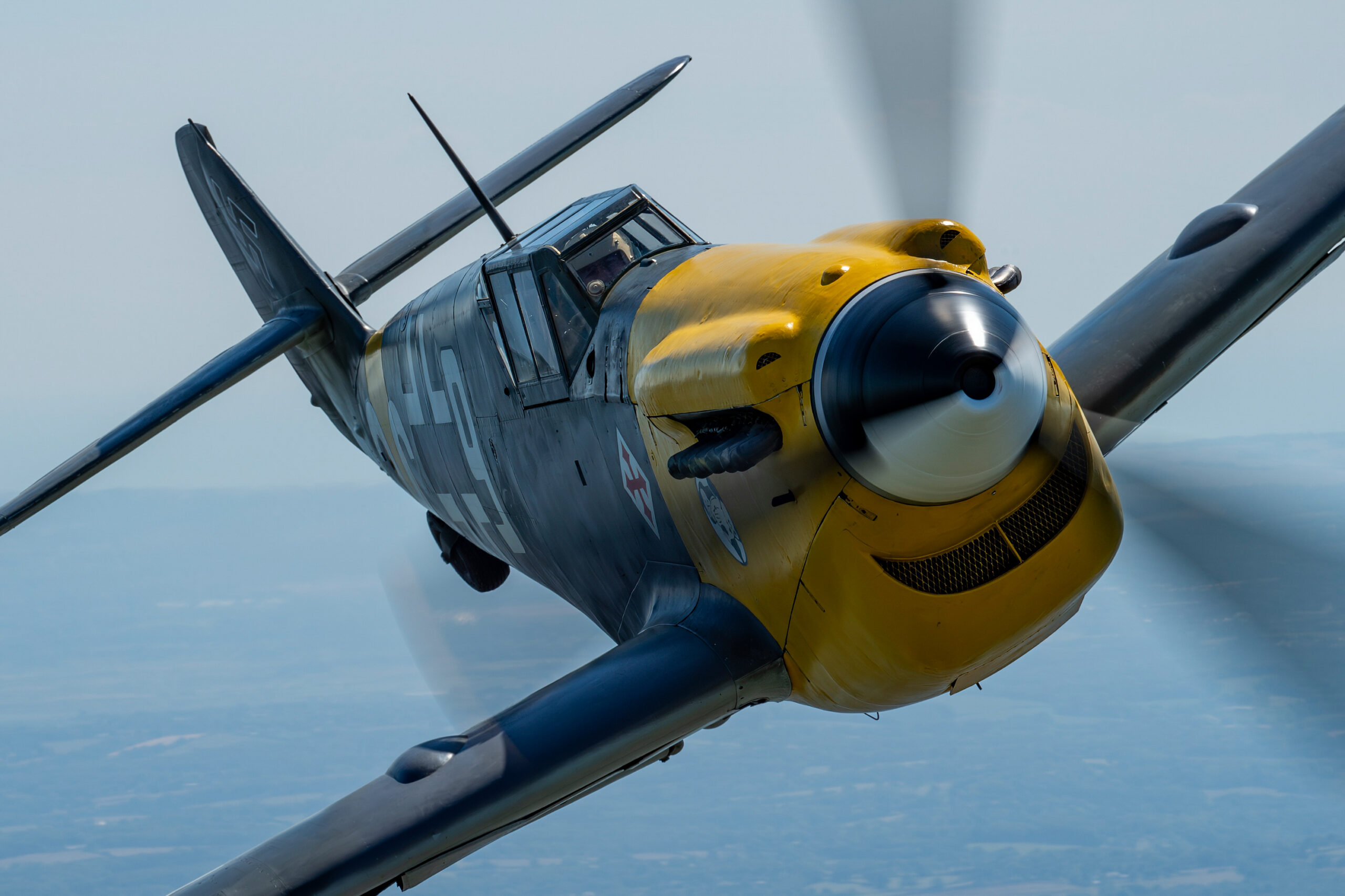 Yellow-nosed Hispano HA-1112-M1L Buchon in wartime Luftwaffe-style markings, photographed close air-to-air