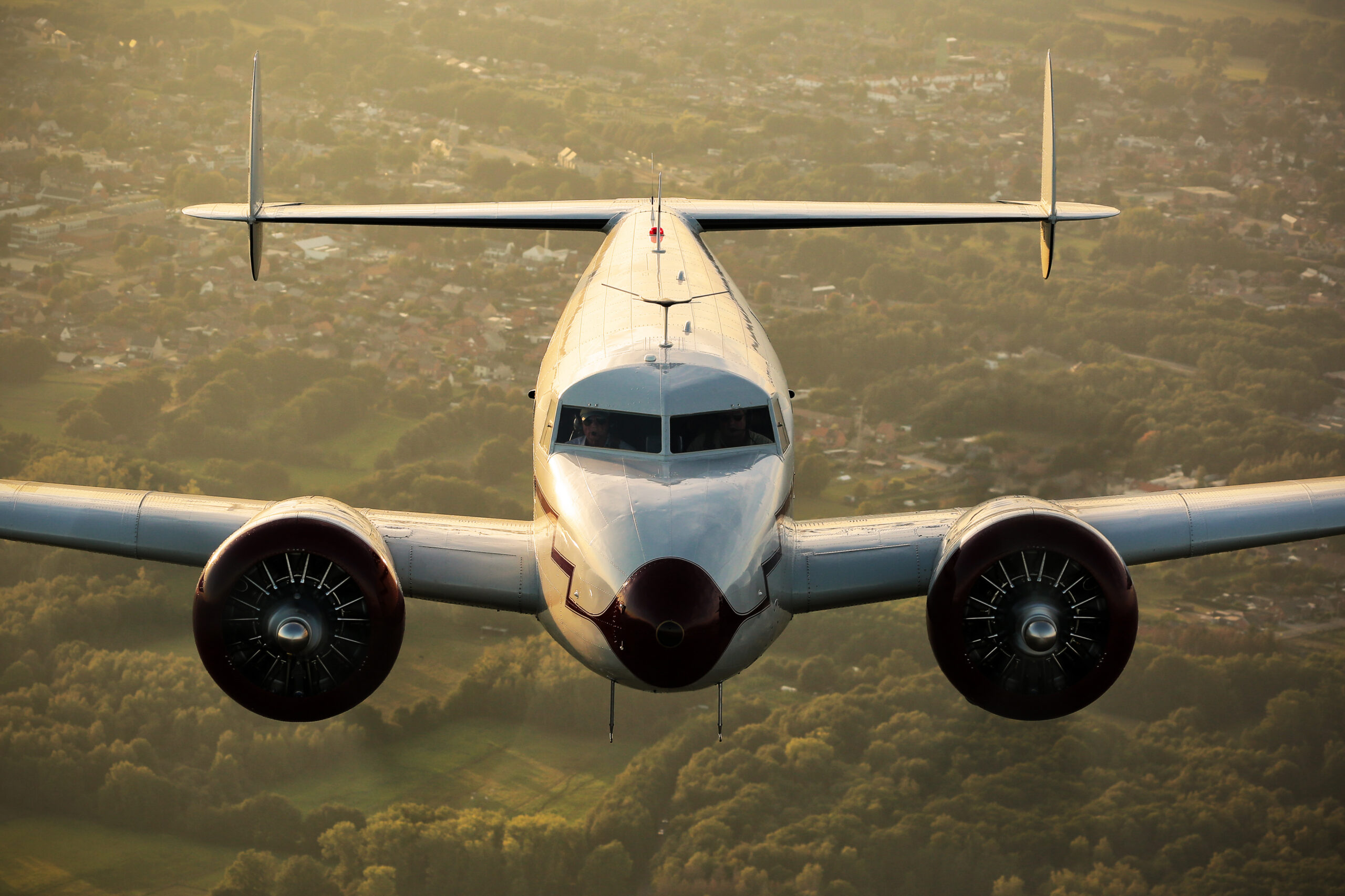 Lockheed 12 Electra Junior head-on with twin radial engines in warm golden evening light