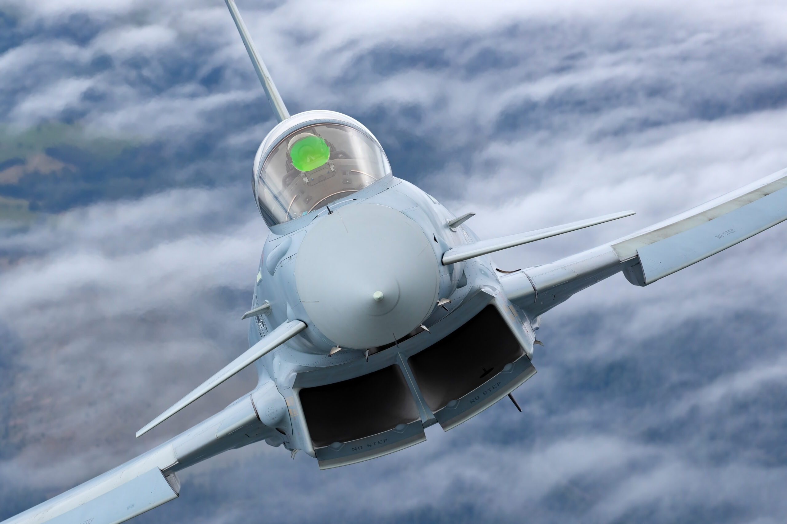Head-on close-up of a Luftwaffe Eurofighter Typhoon banking towards the camera, the pilot's green helmet clearly visible in the cockpit