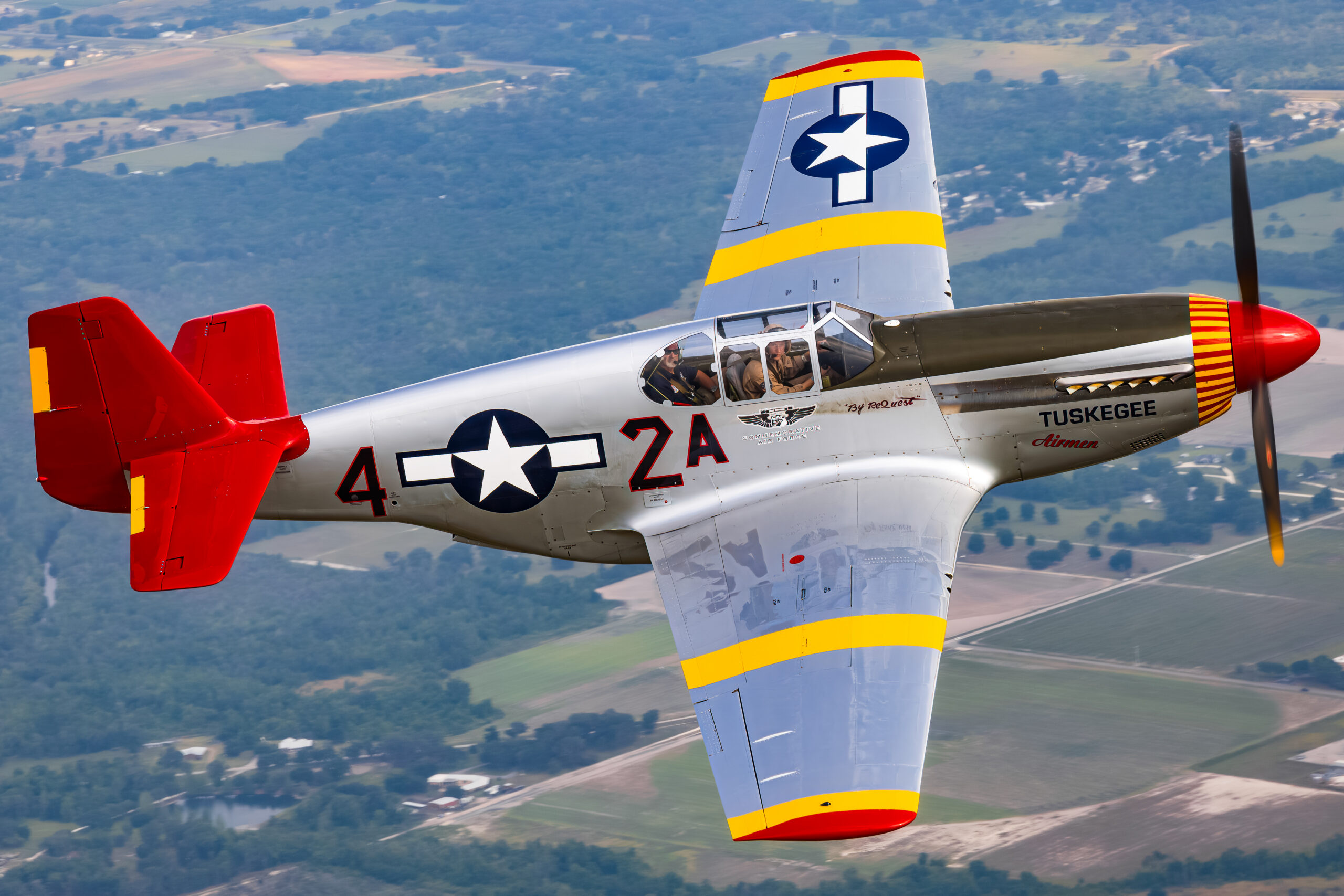 Red-tailed North American P-51C Mustang in Tuskegee Airmen colours banking in flight