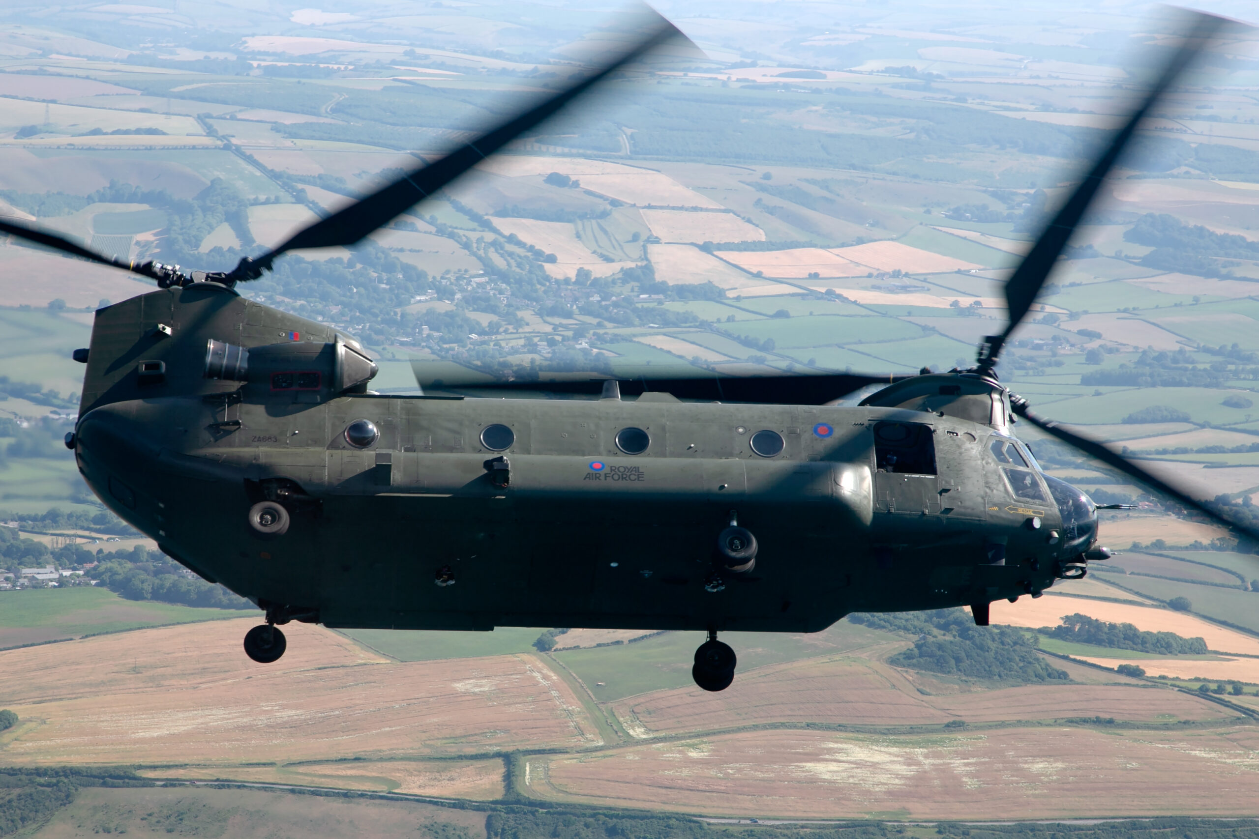 Royal Air Force Boeing Chinook HC6A air to air over fields with both rotors blurred