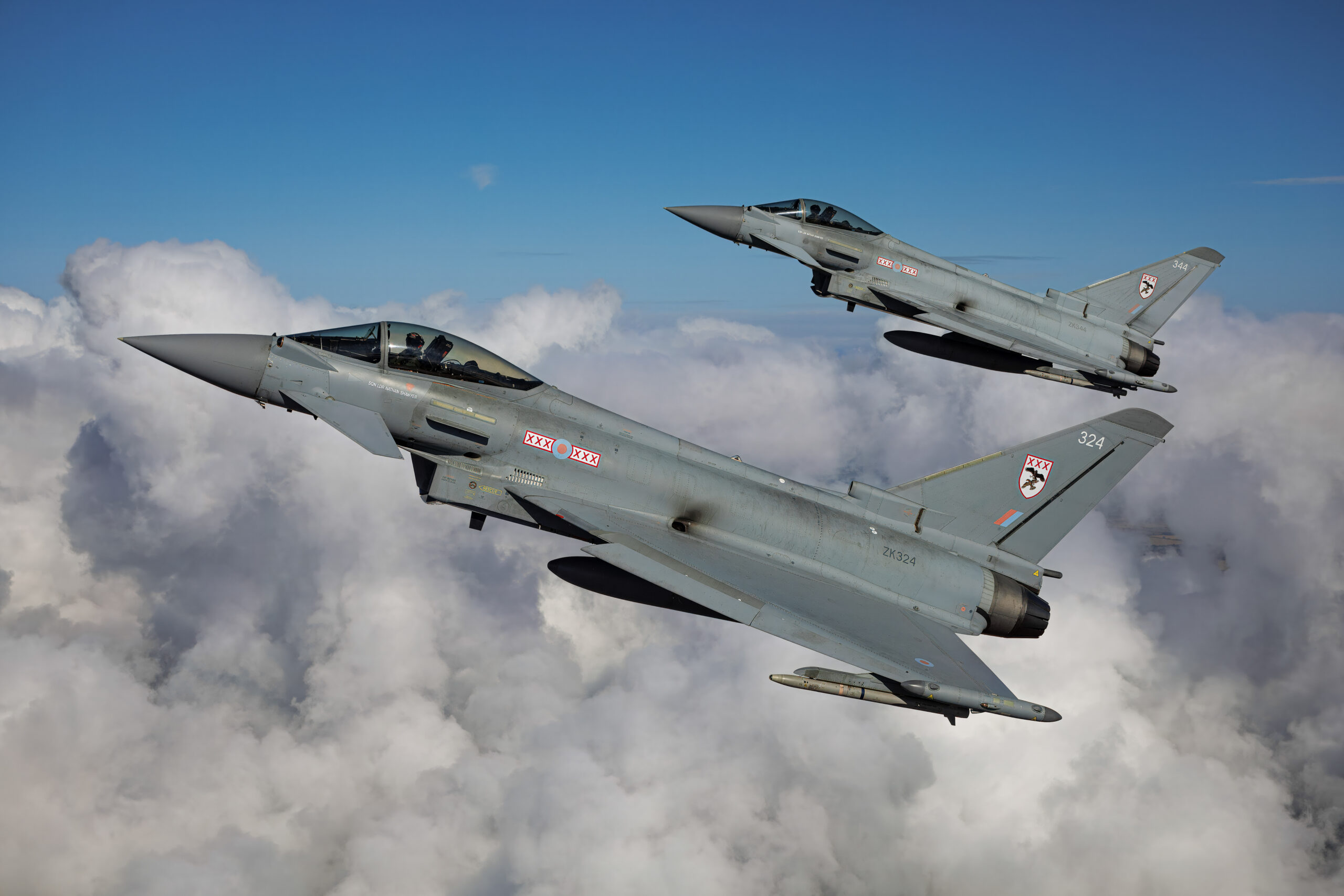 Two RAF Eurofighter Typhoon FGR4s over towering clouds, air to air at RIAT