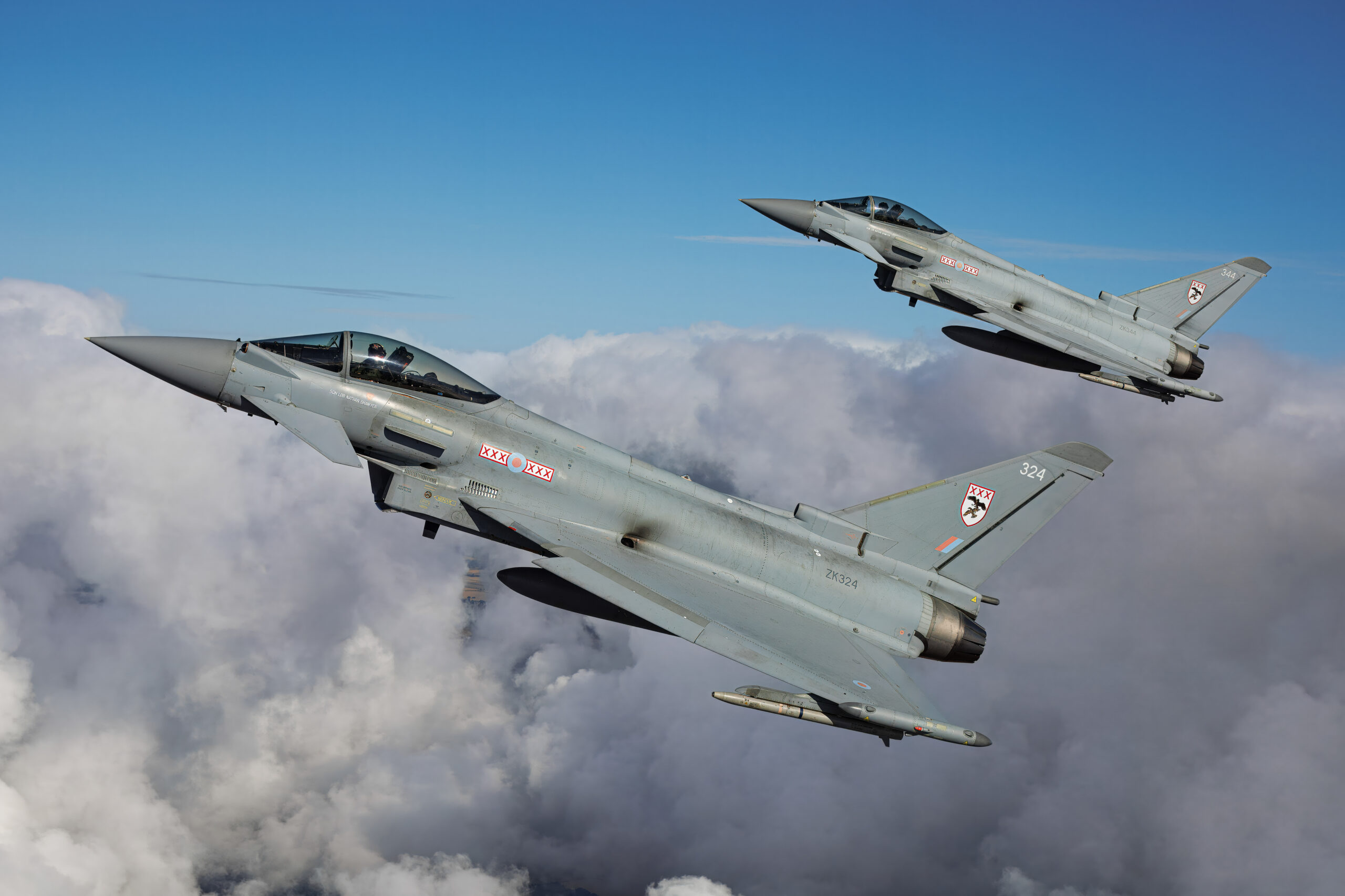 Two RAF Eurofighter Typhoon FGR4 aircraft in close formation over clouds, air to air