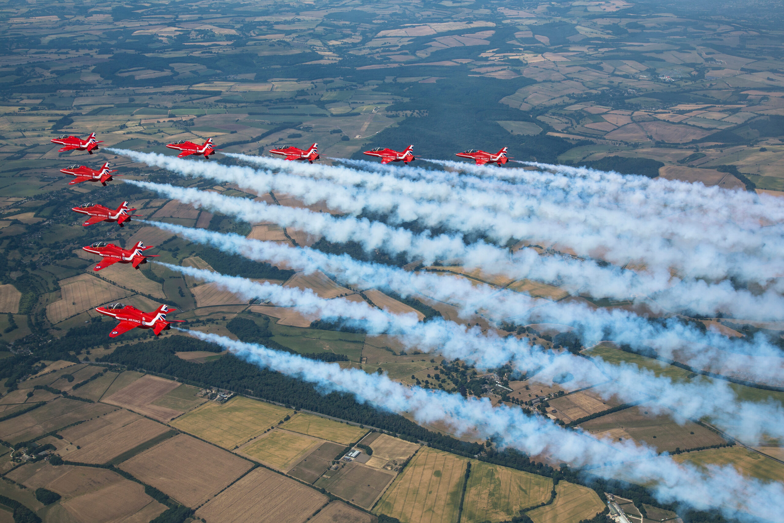 Red Arrows Hawk T1 jets in formation trailing long white smoke trails