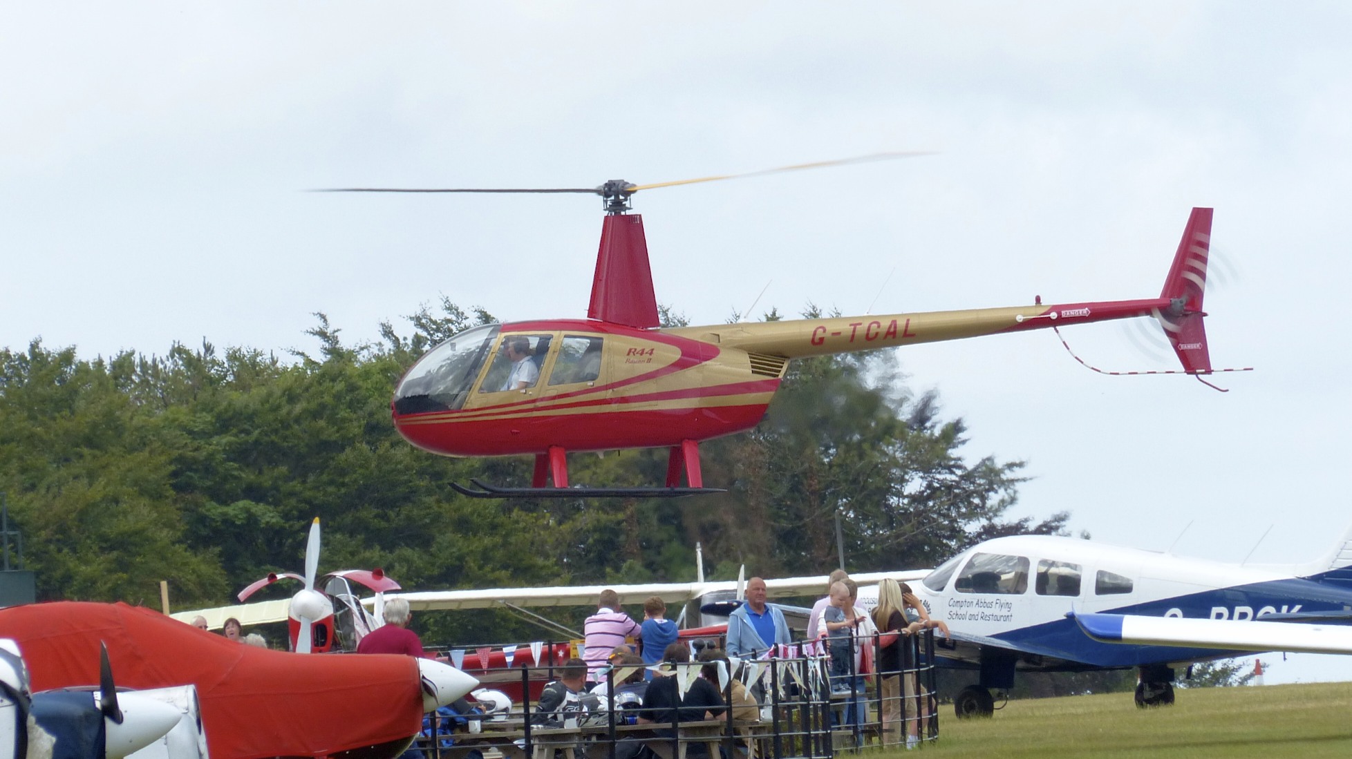 Robinson R44 Raven II hovering at Compton Abbas airfield with the main rotor fully blurred