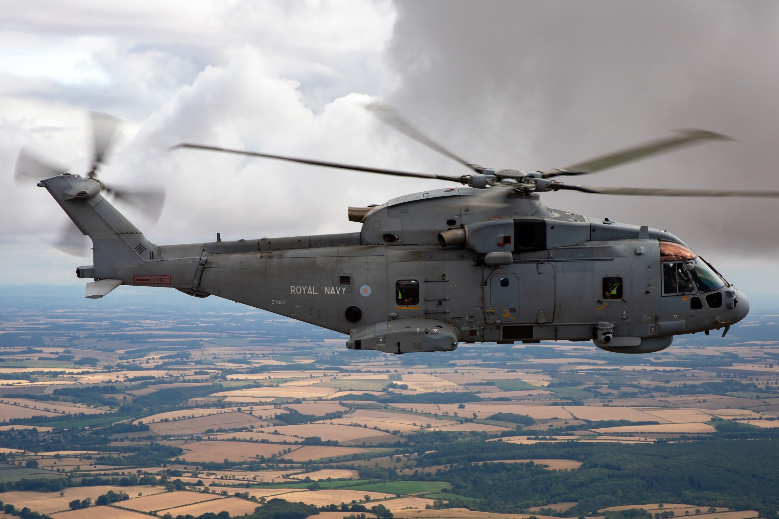 Royal Navy Merlin HM2 side-on over fields with ROYAL NAVY titles and serial ZH832 on the fuselage
