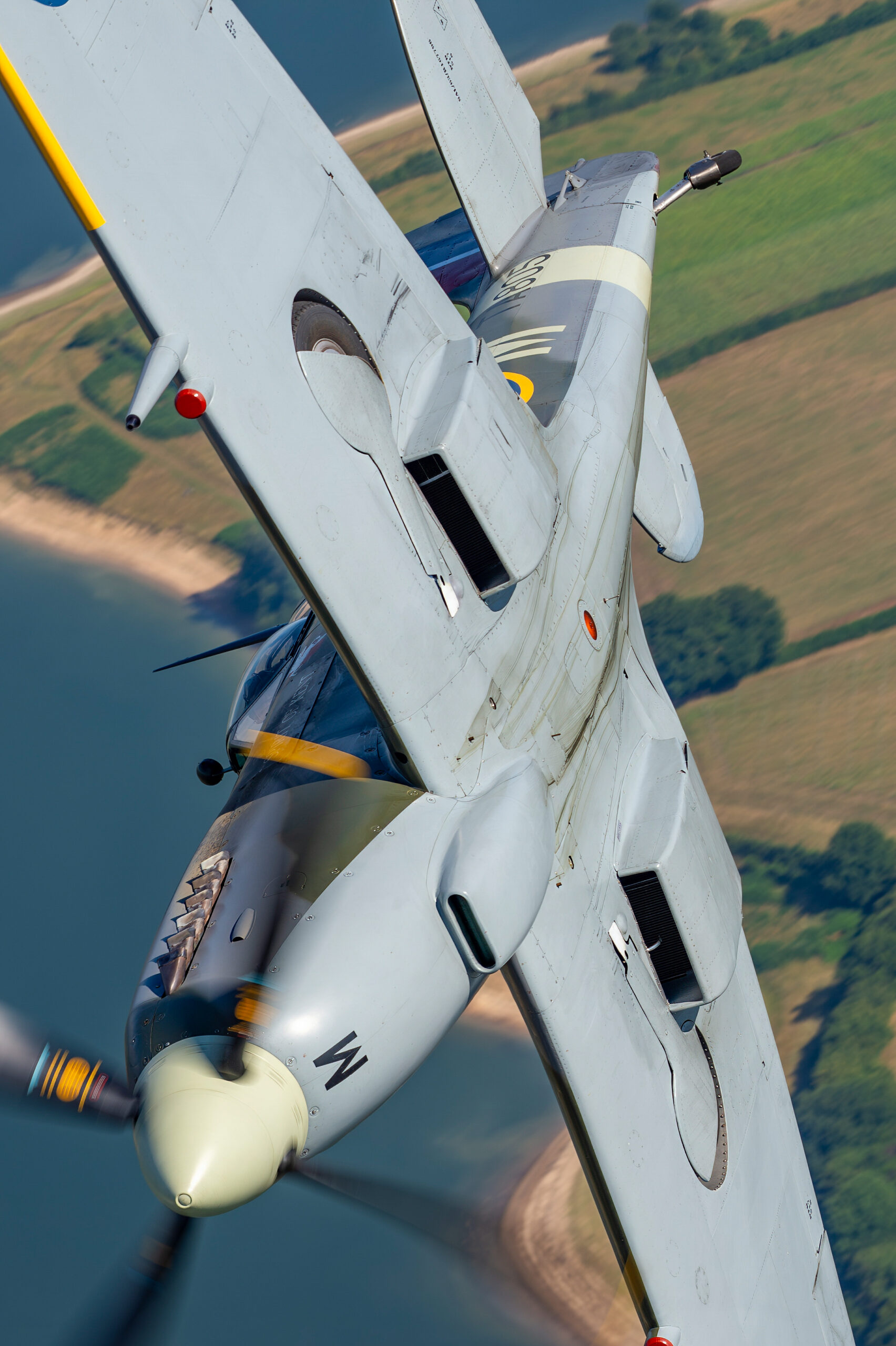 Topside view of a Supermarine Seafire over the coastline
