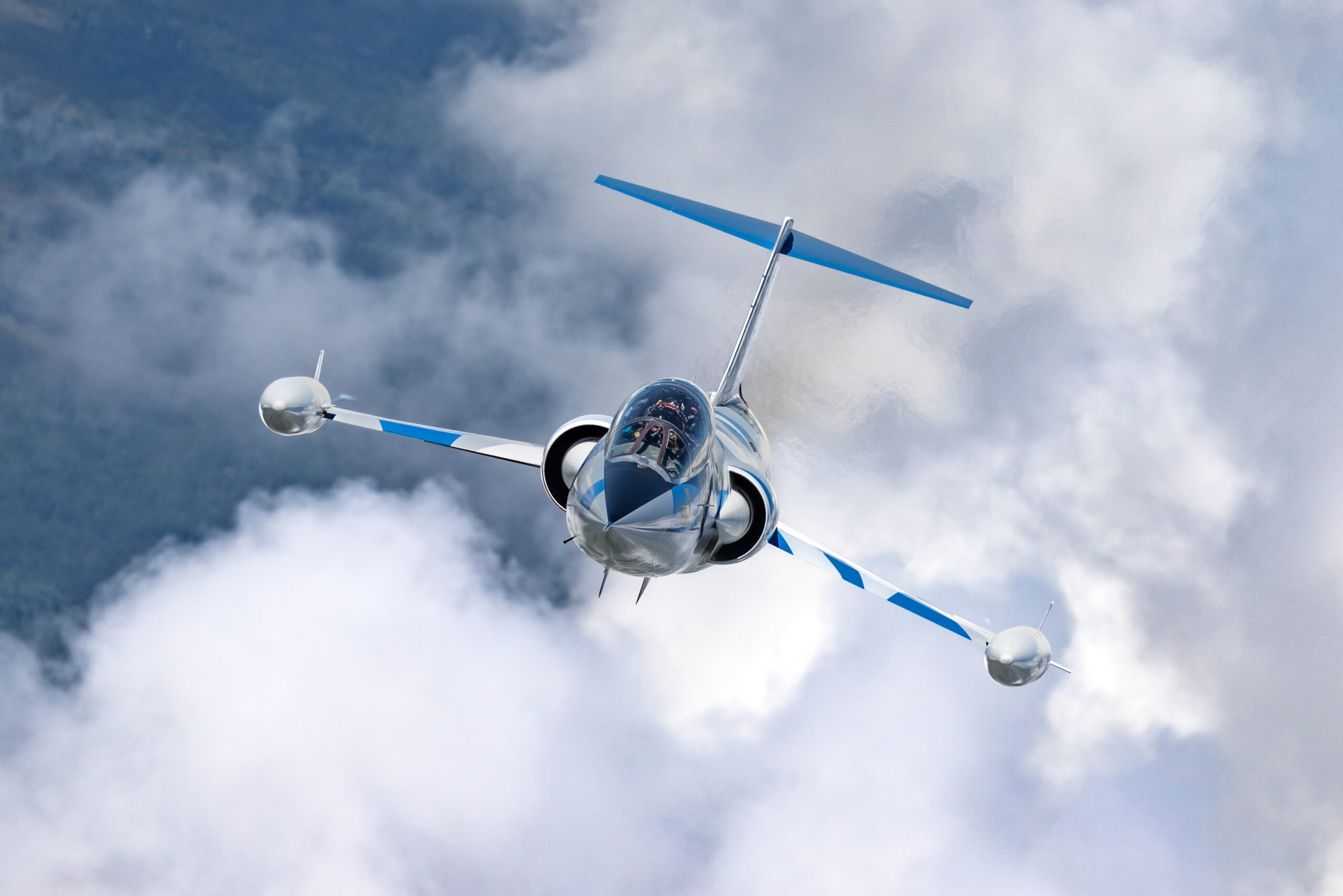 TF-104G Starfighter head-on among clouds showing wingtip tanks