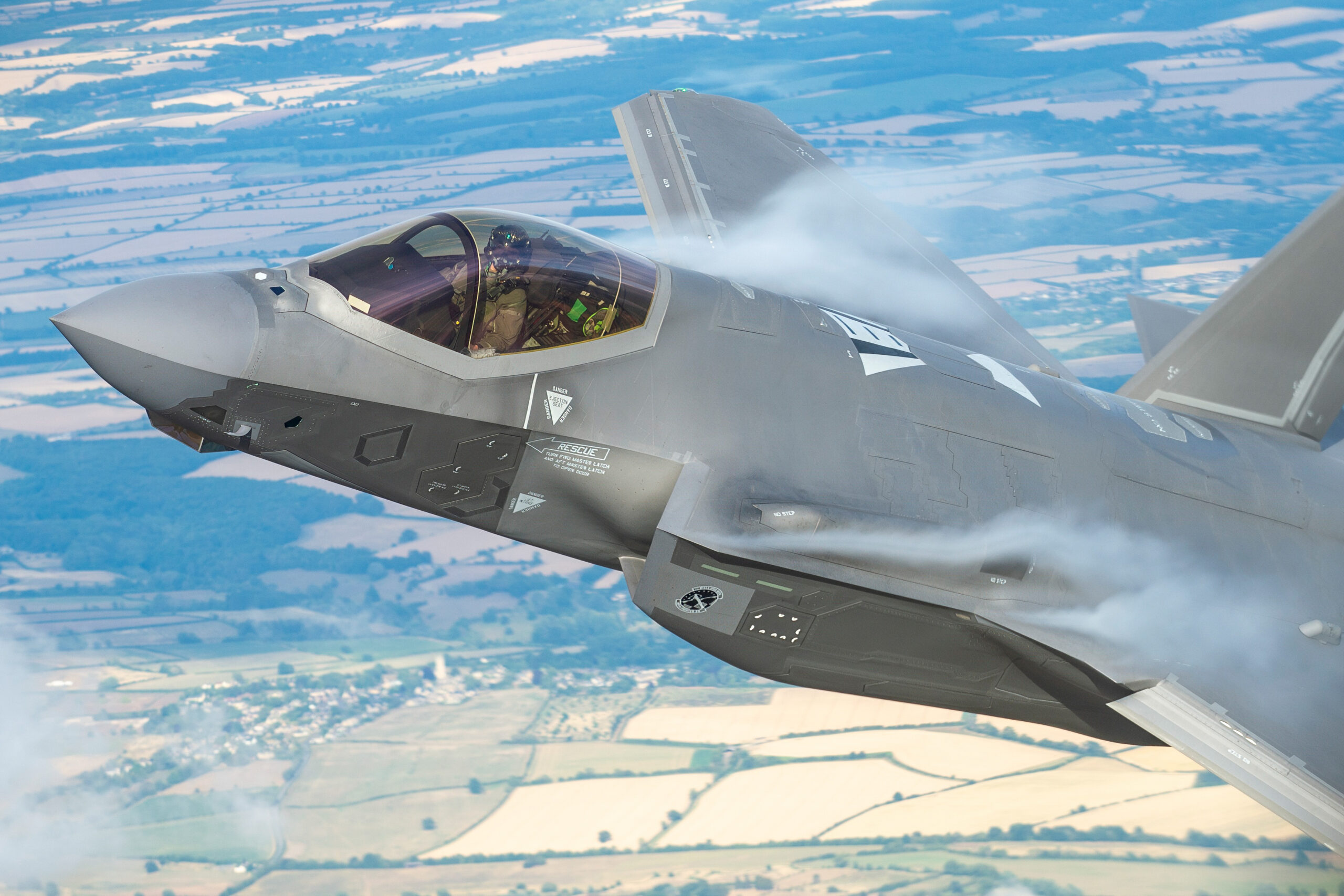 Close-up of a USAF F-35A cockpit and forward fuselage over English fields