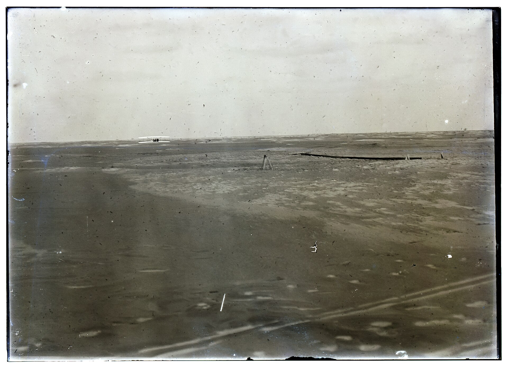 The Wright Flyer far down the sand at the end of its fourth and final flight on 17 December 1903