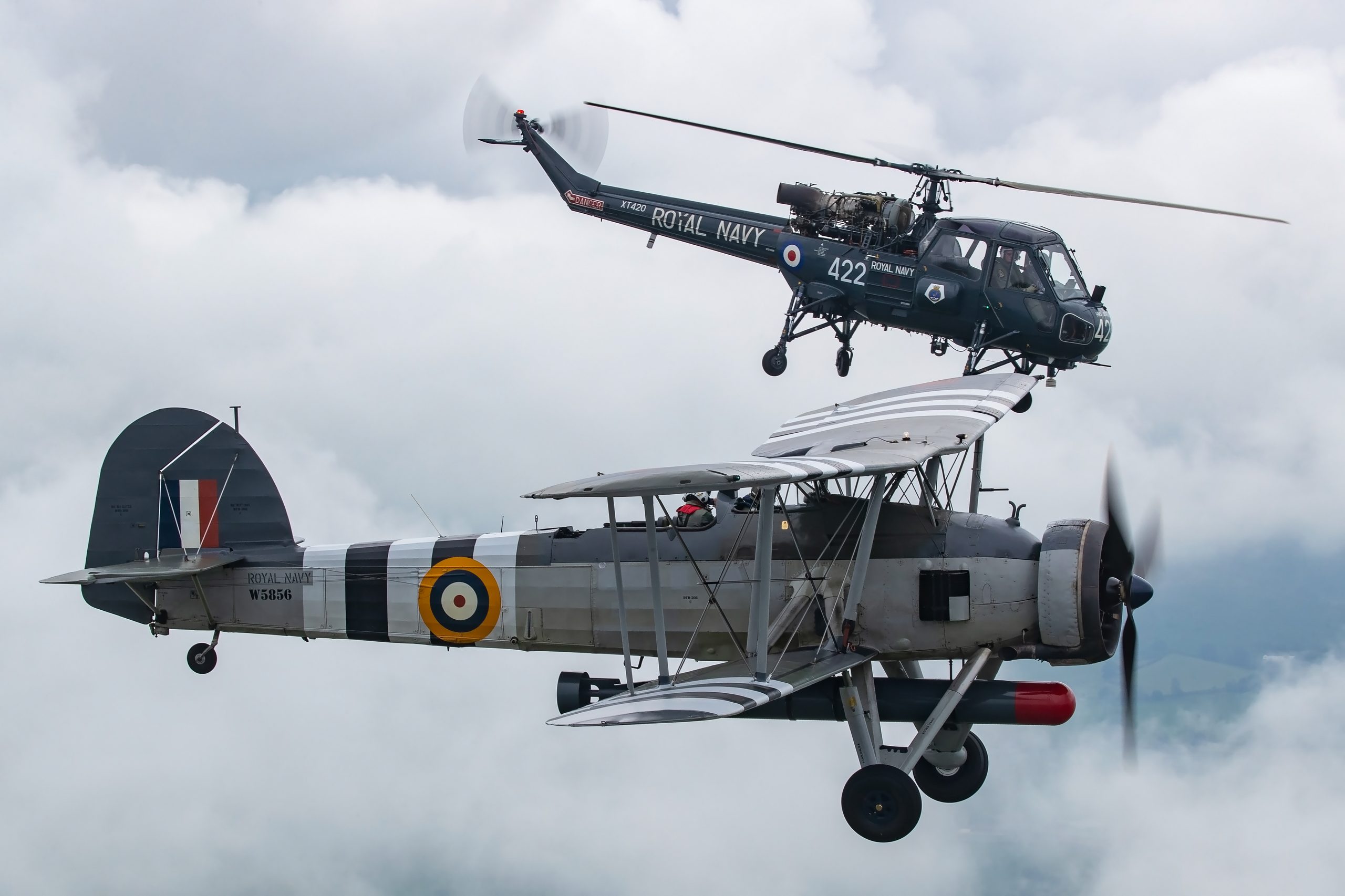 Fairey Swordfish W5856 in D-Day stripes with a Royal Navy Wasp helicopter, air to air