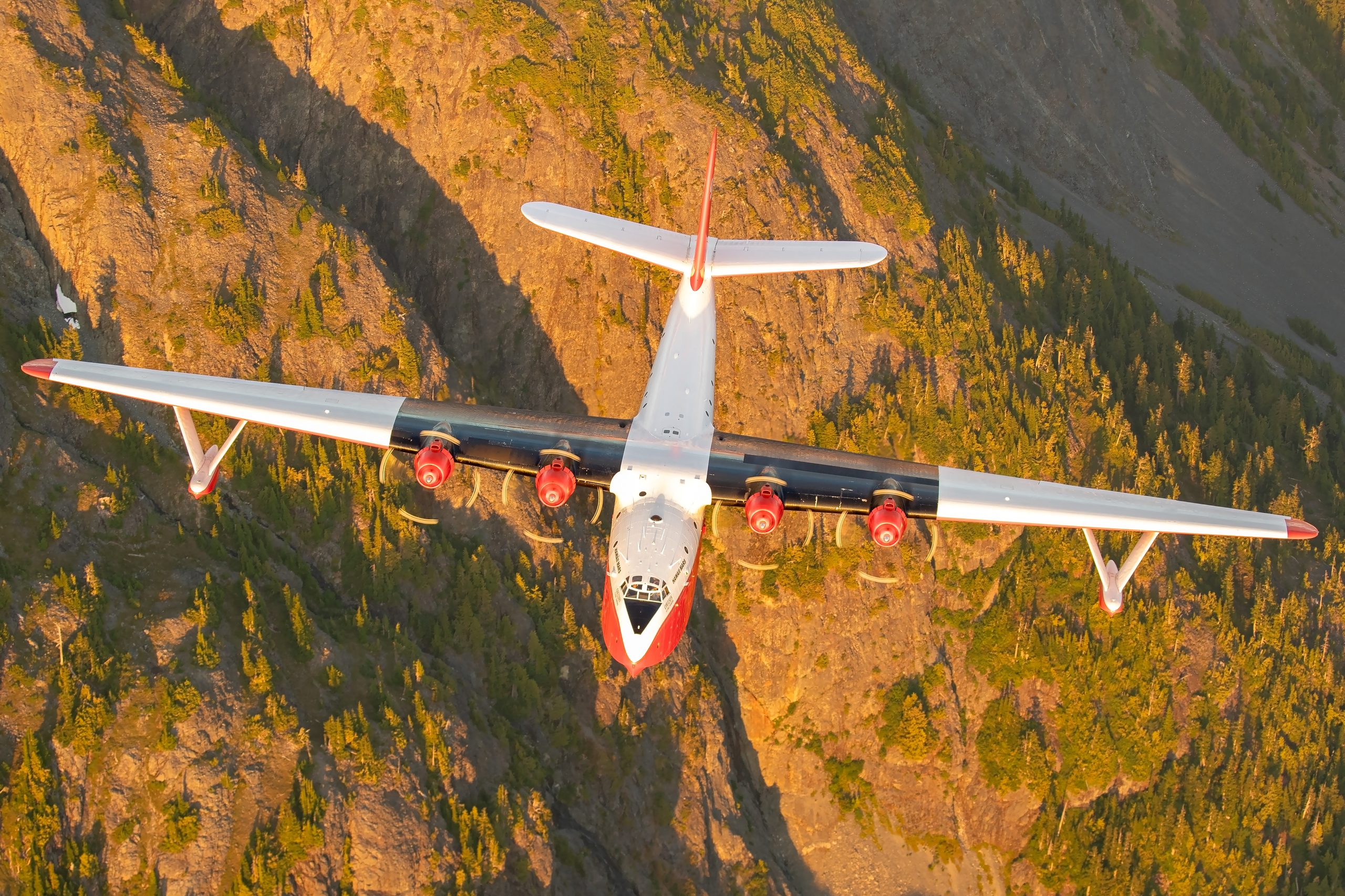 Martin JRM Hawaii Mars against a golden mountainside, air to air