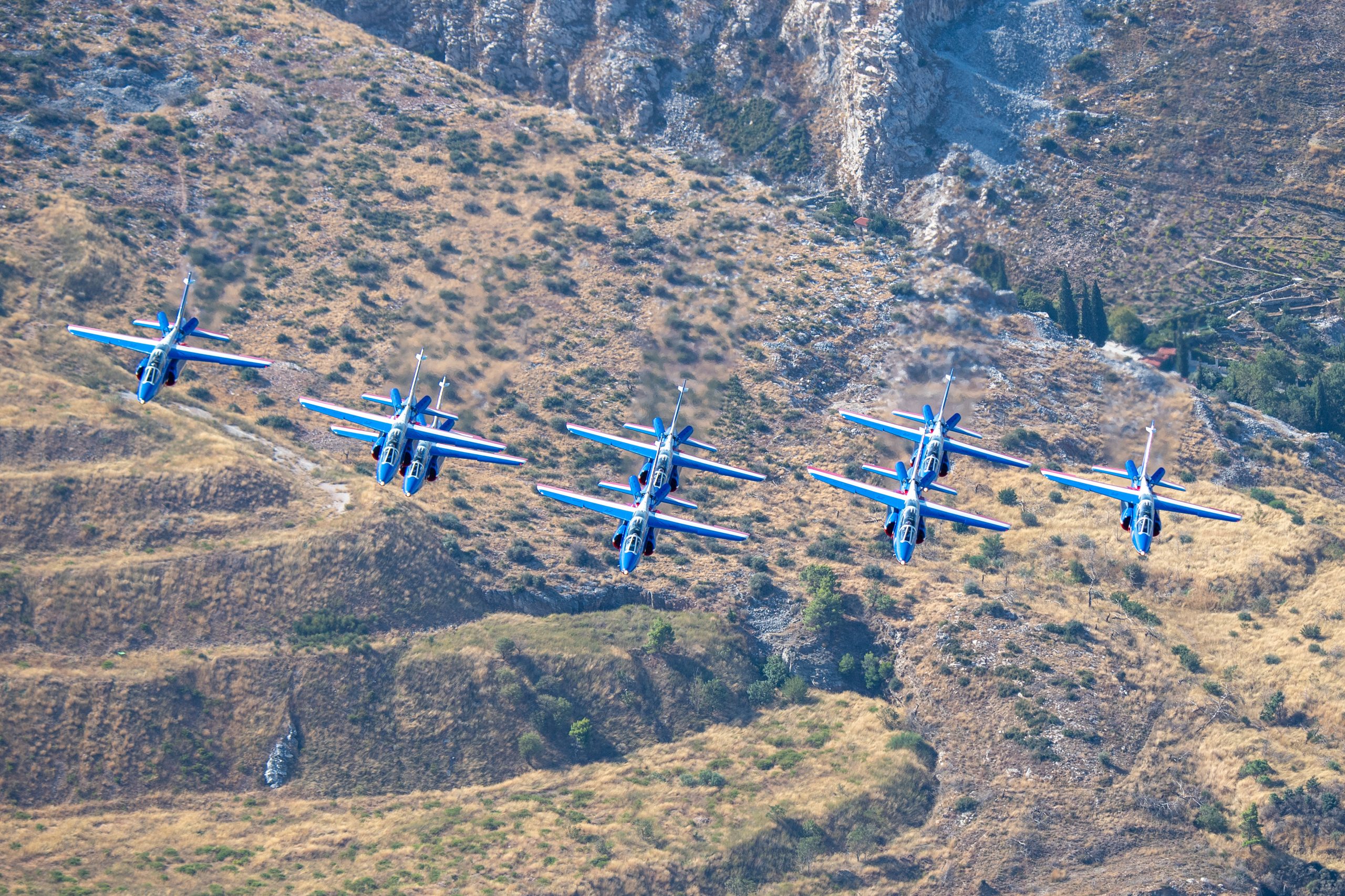 Patrouille de France line abreast over Greek mountains, air to air