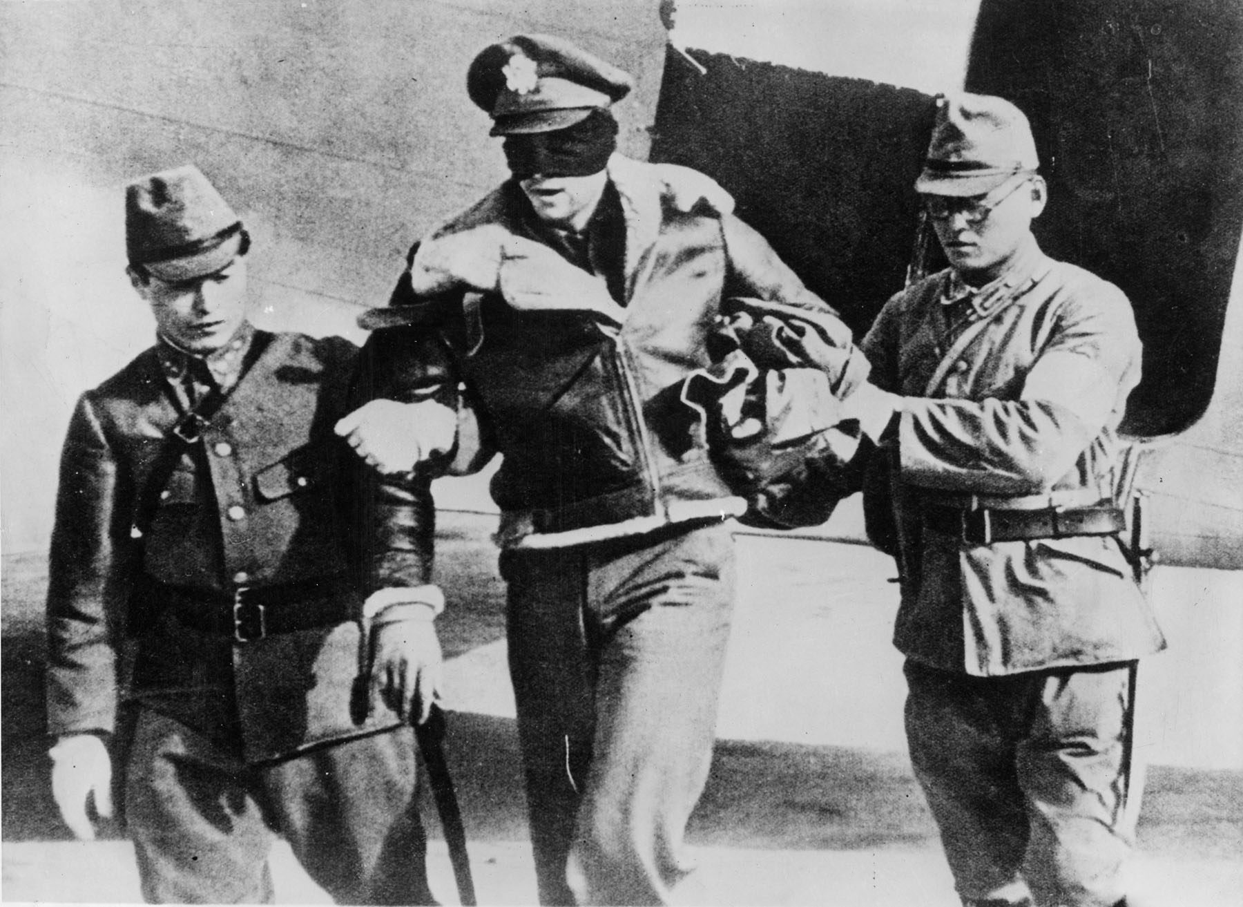 Captured Doolittle Raider Lieutenant Robert Hite, blindfolded, led by Japanese soldiers, 1942