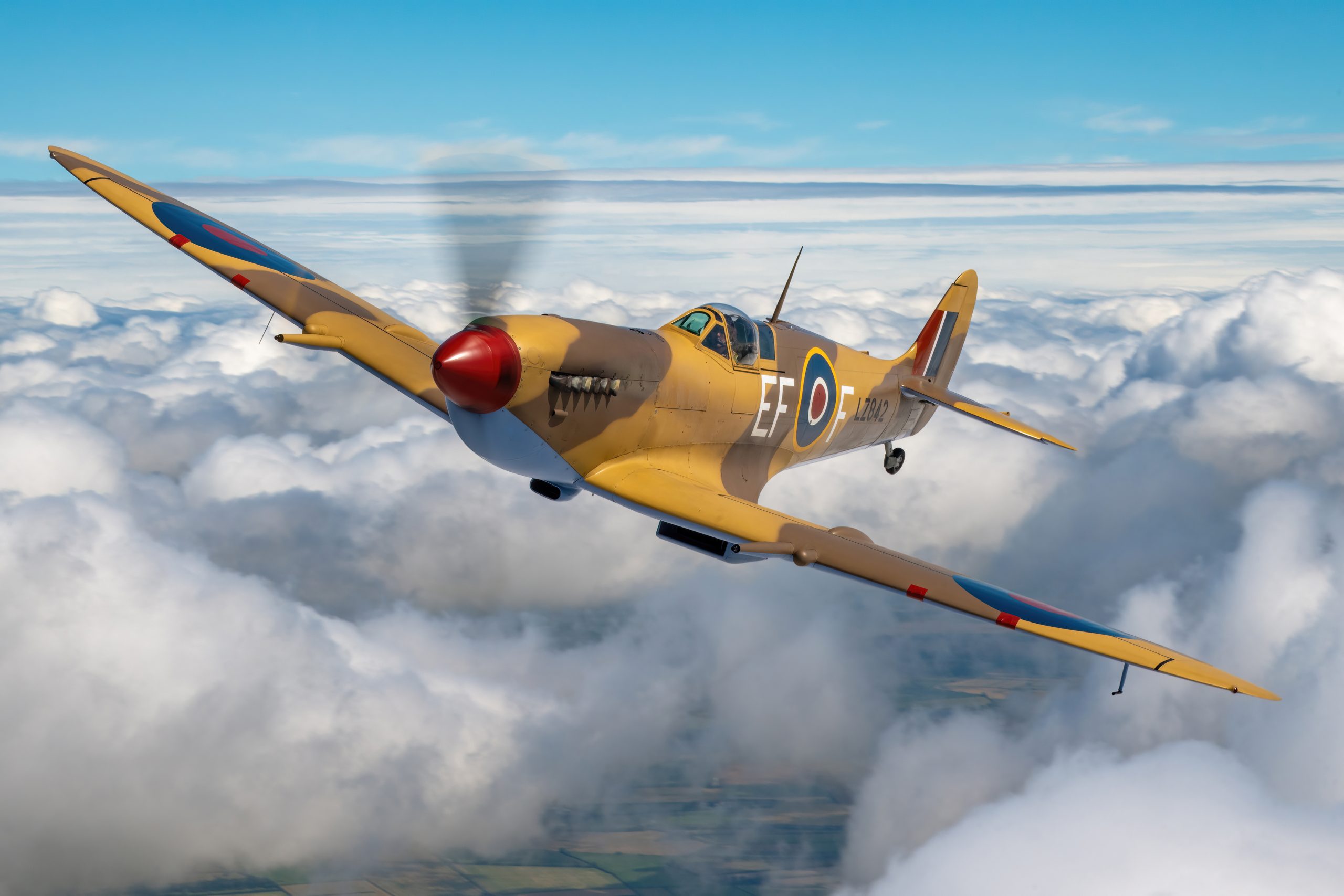 Supermarine Spitfire Mk IX in desert camouflage photographed air-to-air above cloud