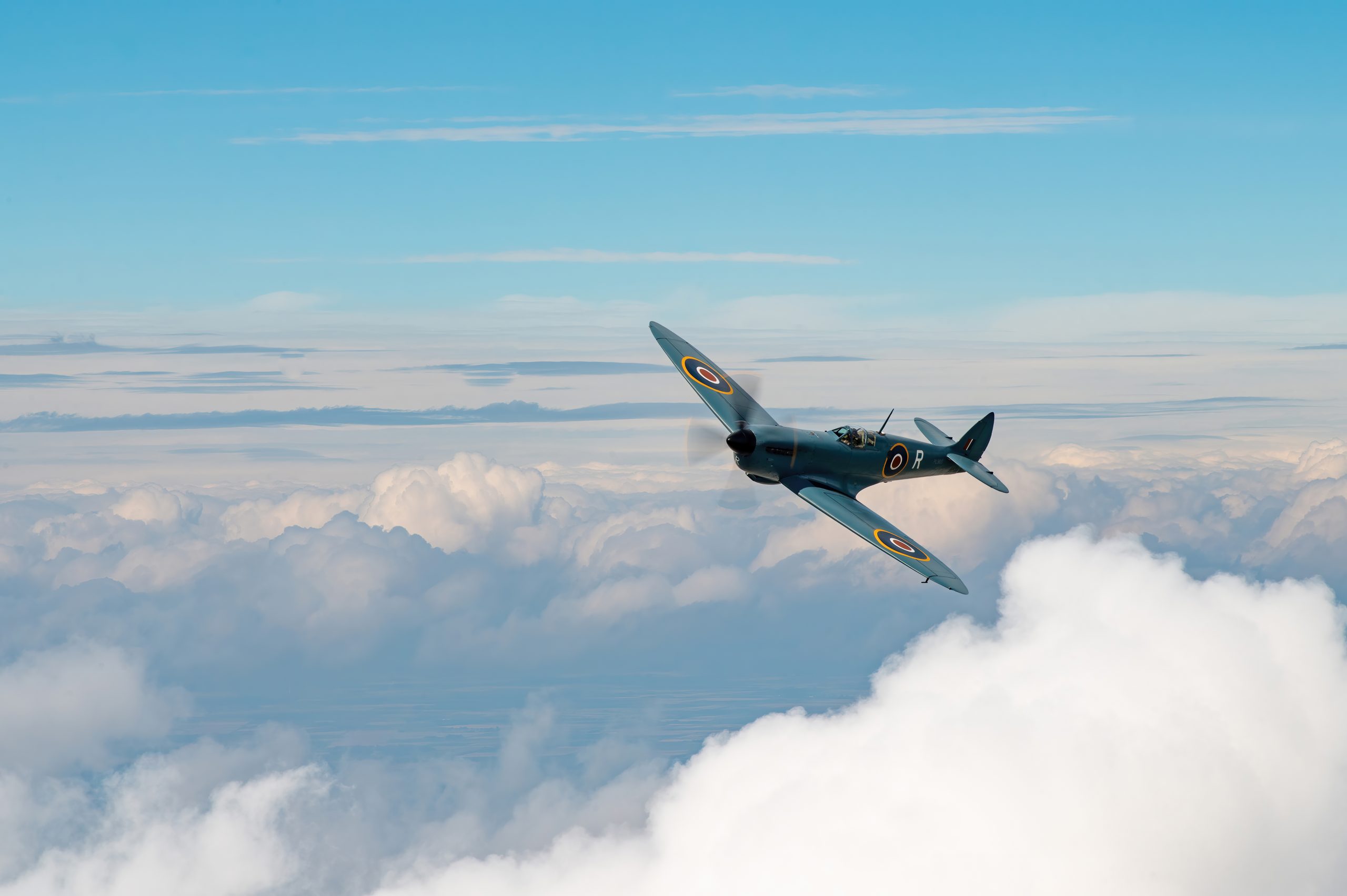 PRU blue Supermarine Spitfire PR XI banking above clouds
