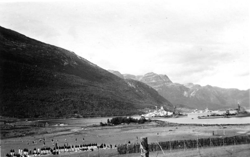 Tirpitz at anchor against the far shore of a Norwegian fjord with mountains behind