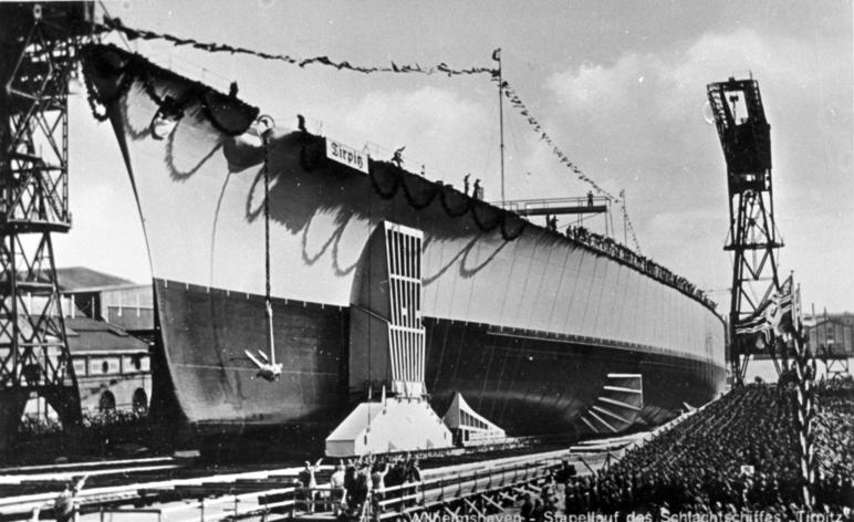 The hull of the battleship Tirpitz on the slipway at Wilhelmshaven at her launch, crowds at the foot of the ways