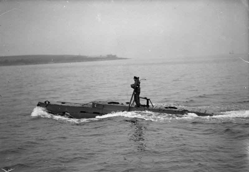 A British X-craft midget submarine running on the surface with her commander standing on the casing