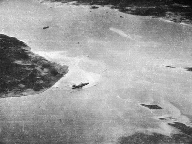 An oblique aerial photograph of the Hakoya anchorage off Tromso with the battleship Tirpitz at her berth