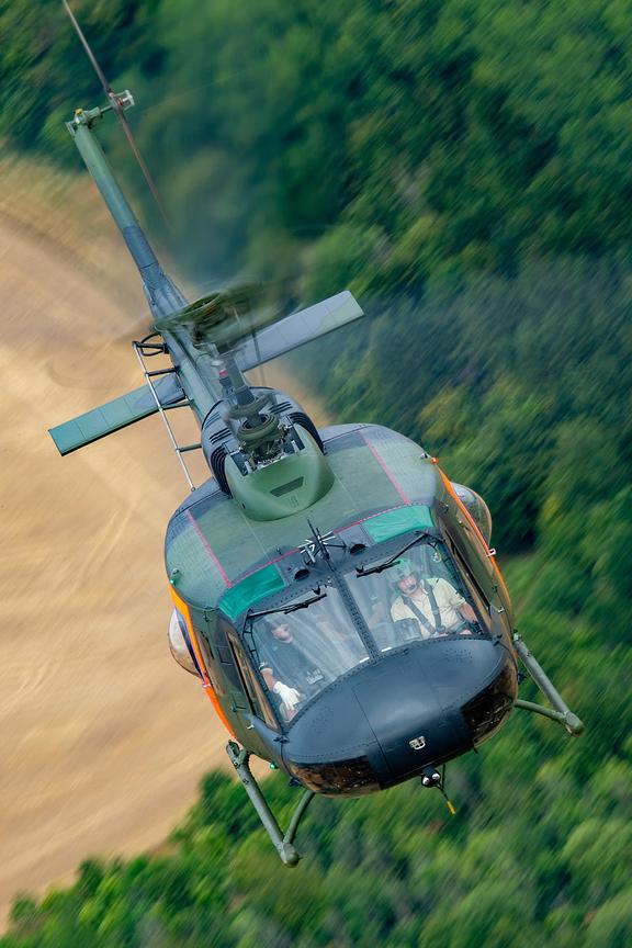 Bell UH-1 Huey head on over woodland, air to air