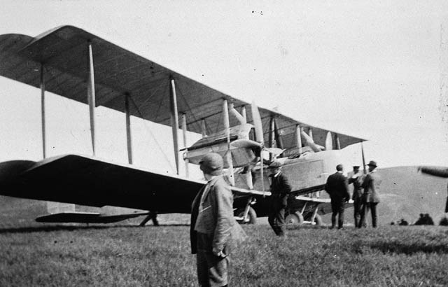 The Vickers Vimy standing on grass at Lester's Field outside St John's with men working around it on the day of the flight