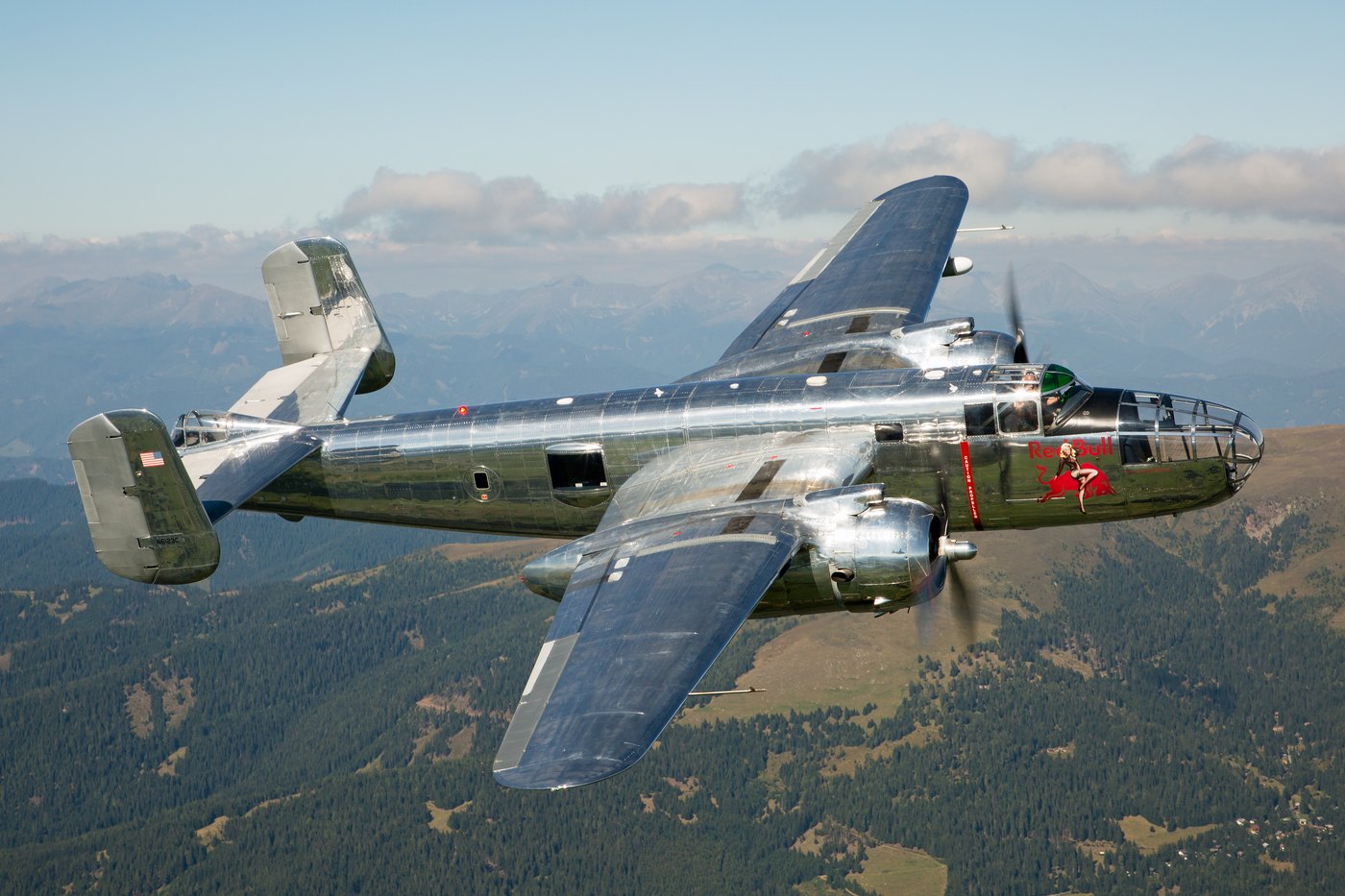 Flying Bulls B-25J Mitchell N6123C in polished bare metal with Red Bull nose art, in flight over Zeltweg in Austria