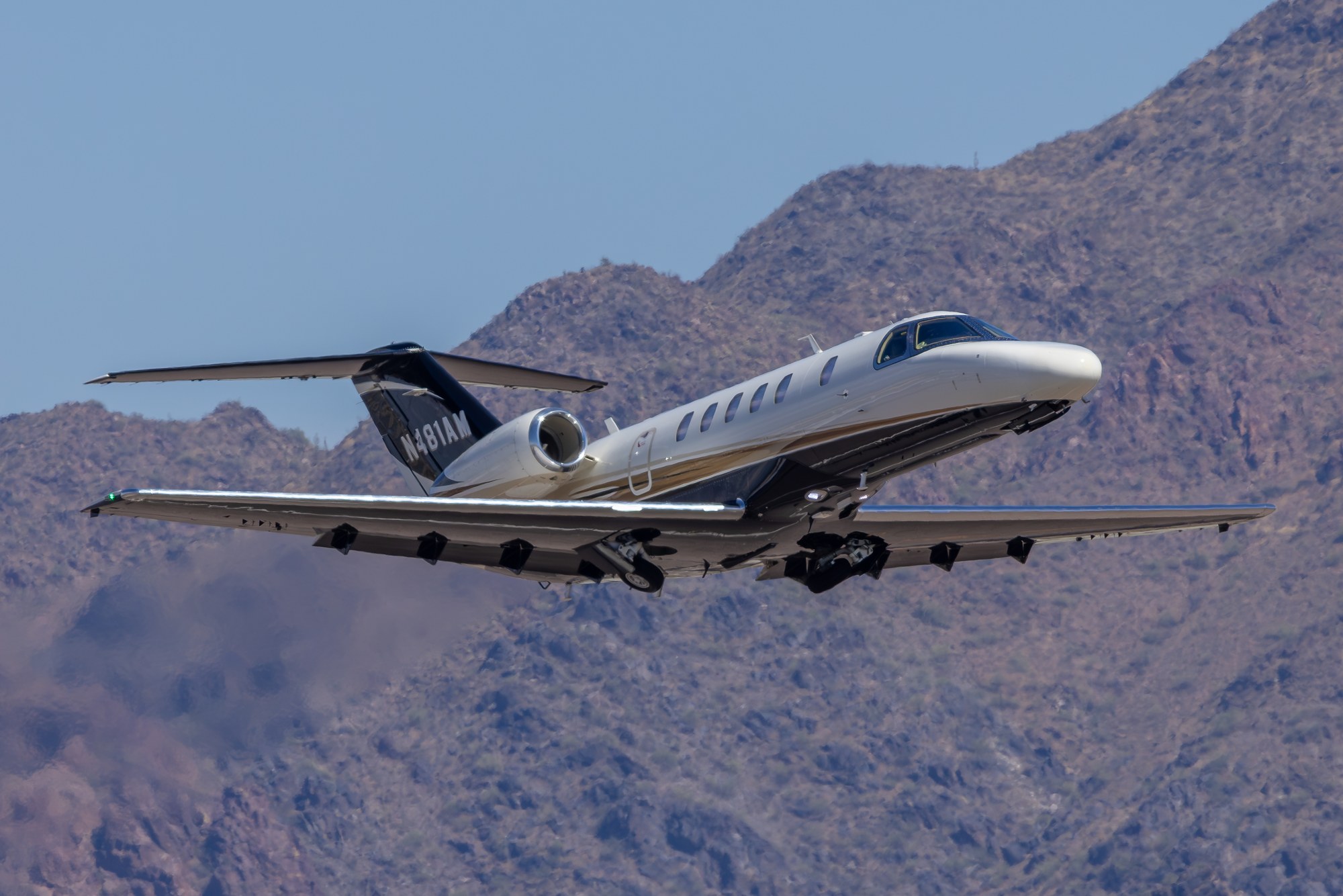 Cessna Citation N481AM rotating off the runway at Scottsdale against a mountainside